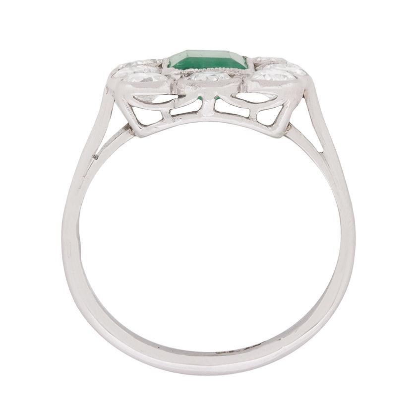 A sparkling frame of diamonds, totalling 1.50 carats, surrounds a lovely 1.00 carat emerald at the focal point of this c.1920s cluster ring.

Art Deco era touches are apparent in the ring’s original platinum setting, which features hand-done