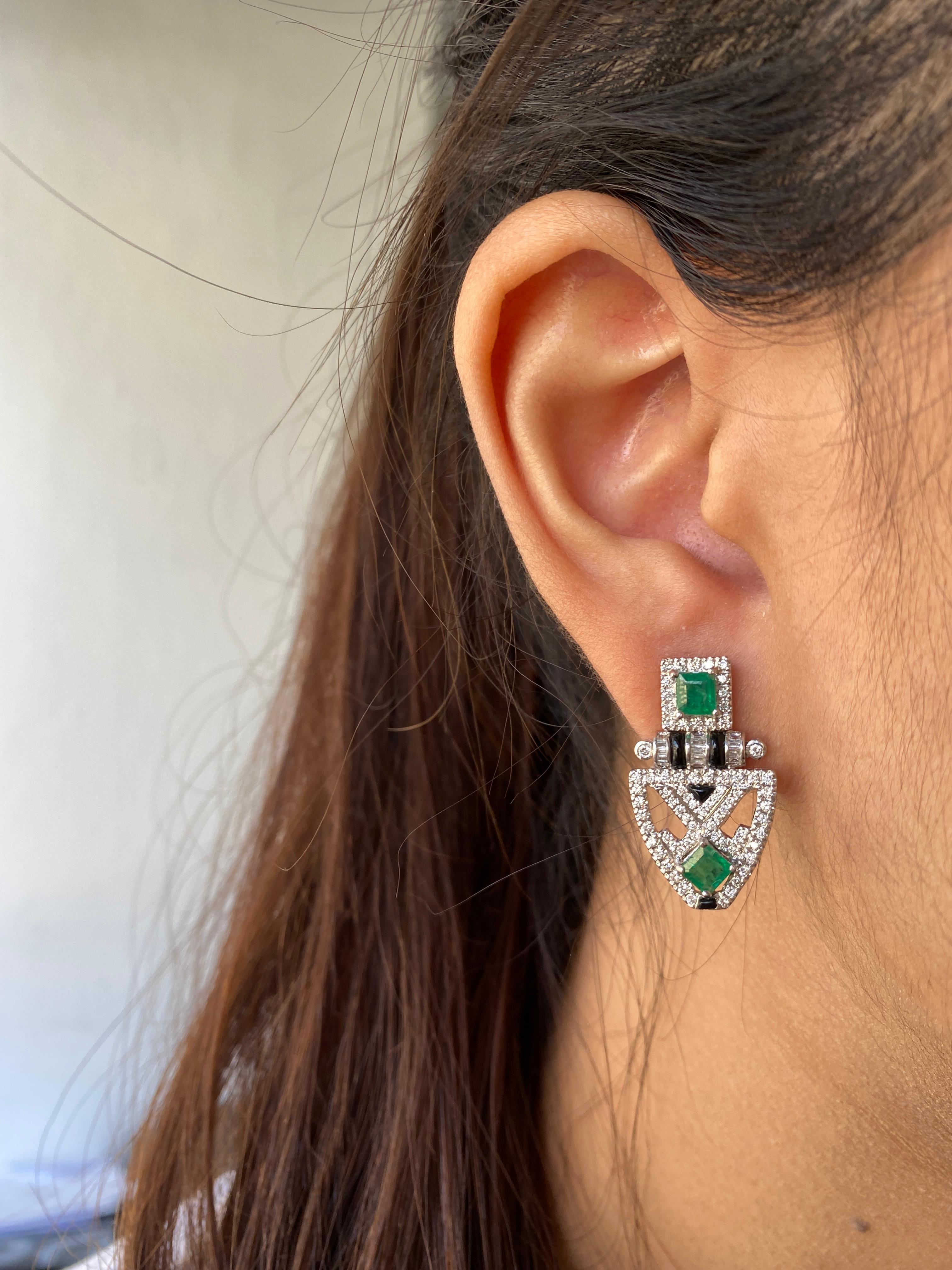 An art-deco inspired pair of earrings, consisting of 1.43 carat Zambian Emeralds and 1.14 carat White Diamonds with Black Onyx - all set in solid 18K White Gold. The measurements are 25mm x 13 mm. These come with a push-pull backing. 
We provide