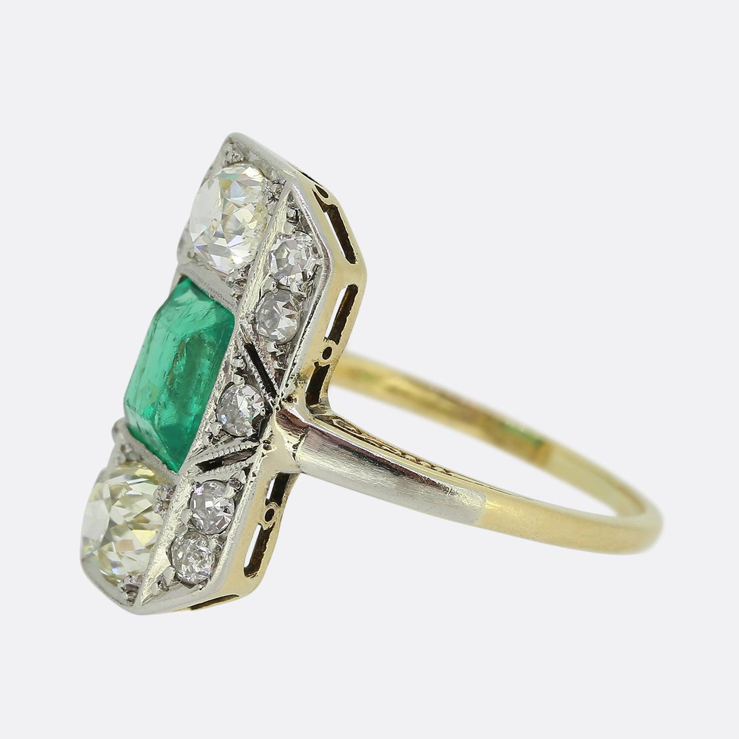Here we have an original Art Deco emerald and diamond plaque ring. An octagonal platinum face plays host to a daring natural emerald possessing a vivd green colour tone. This principle stone is top and tailed by a single chunky old mine cut diamond
