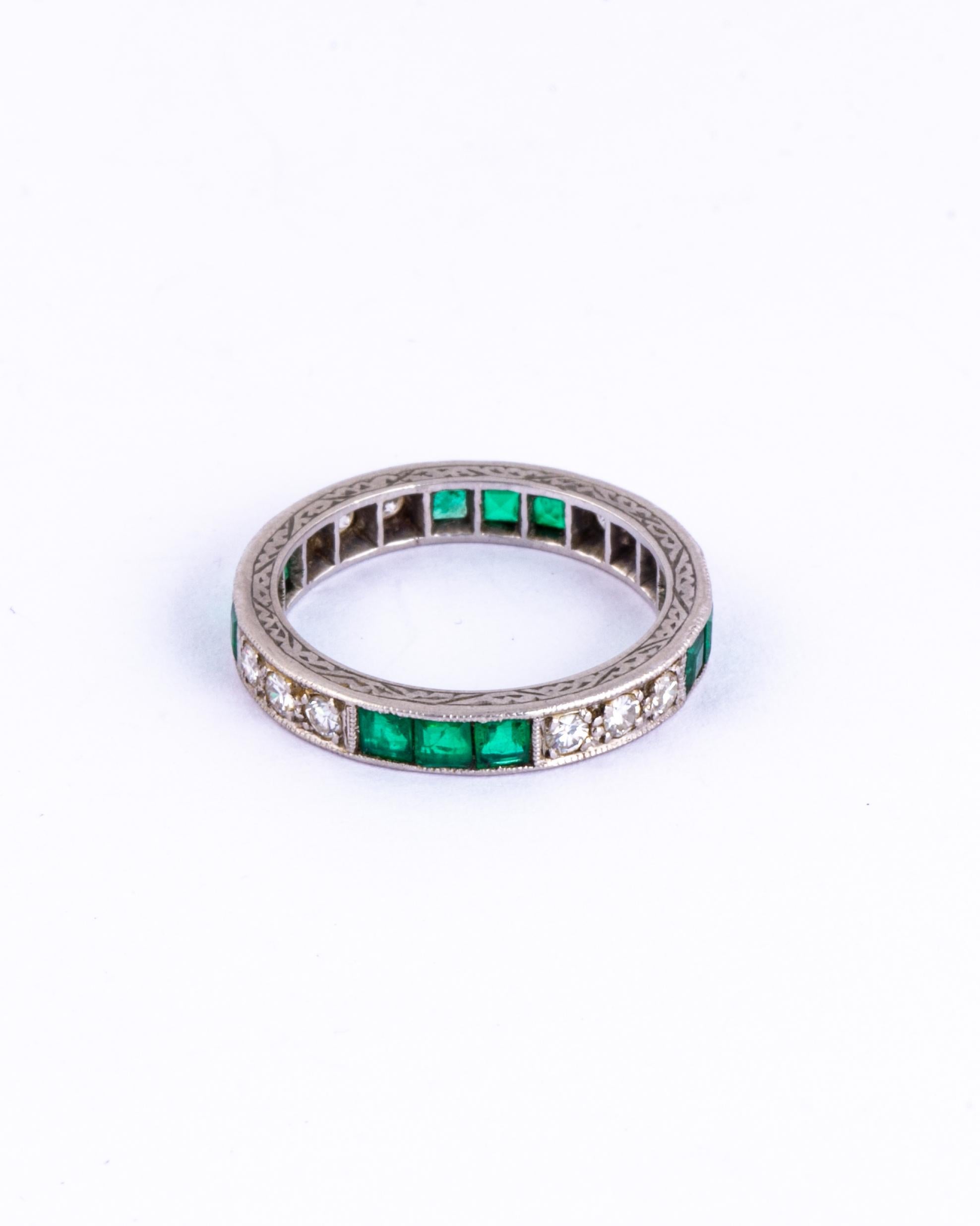 A stunning Art Deco eternity band ring fully set with emeralds and diamonds. Alternating trios of square cut green emeralds measuring 10pts each are set between a trios of round-cut white diamonds measuring 5pts each all around this wonderful ring.