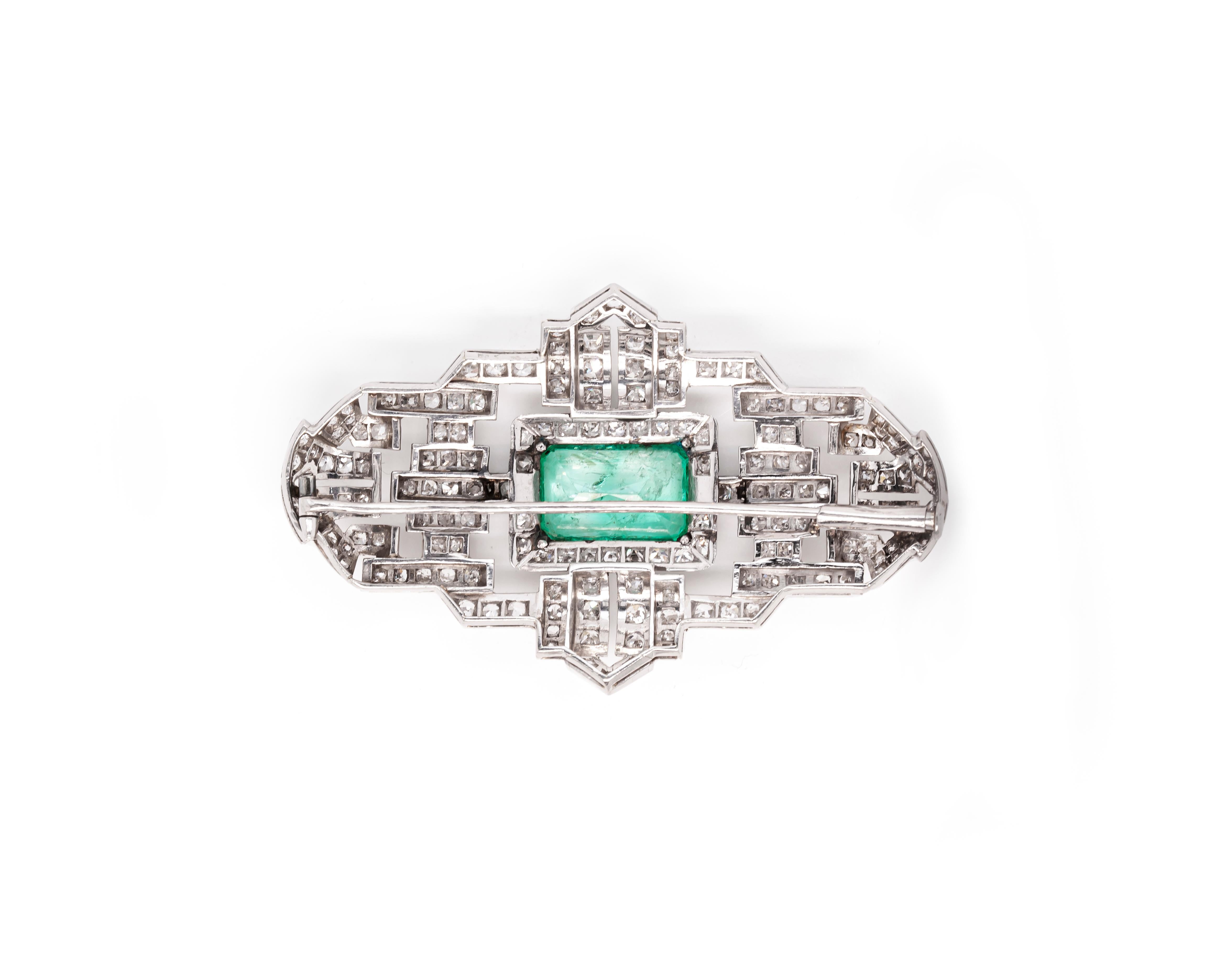 This one of a kind Art Deco brooch showcases a geometric open work design finely crafted from solid platinum. Taking centre stage is a wonderful emerald cut emerald, weighing approximately 6.50ct, mounted in a rubover milgrain edged, open back
