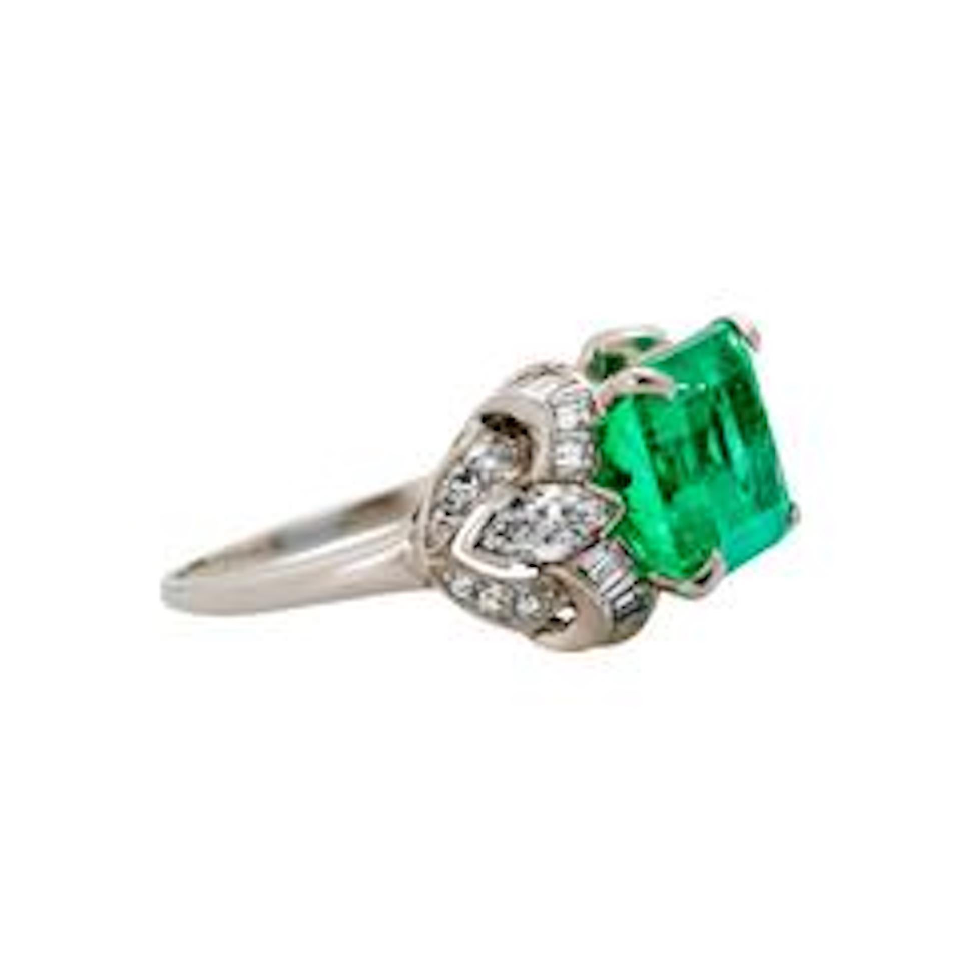 Kentshire is a spectacular platinum, diamond and natural emerald evening ring from the Art Deco era circa 1935. The ring features a magnificent GIA certified 4.97ct Columbian emerald measuring 11.38 x 9.22 x 6.60 mm. The beautiful center stone is