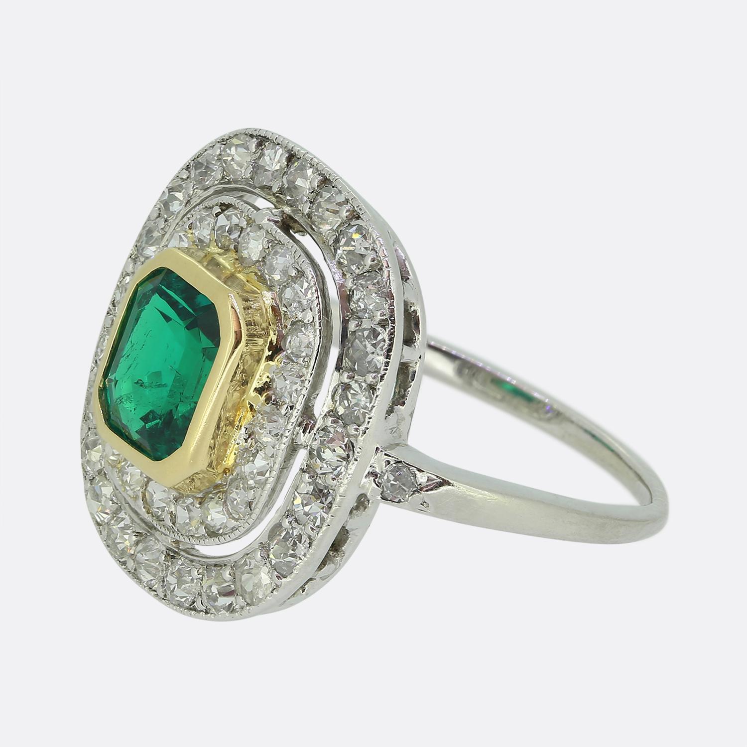 Hier haben wir einen außergewöhnlichen Art-Deco-Ring mit Smaragd und Diamanten im Cluster. Ein einzelner Smaragd im Smaragdschliff mit lebhaftem, elektrisch grünem Farbton sitzt leicht erhöht in einer warmen Fassung aus 18 Karat Gelbgold in der