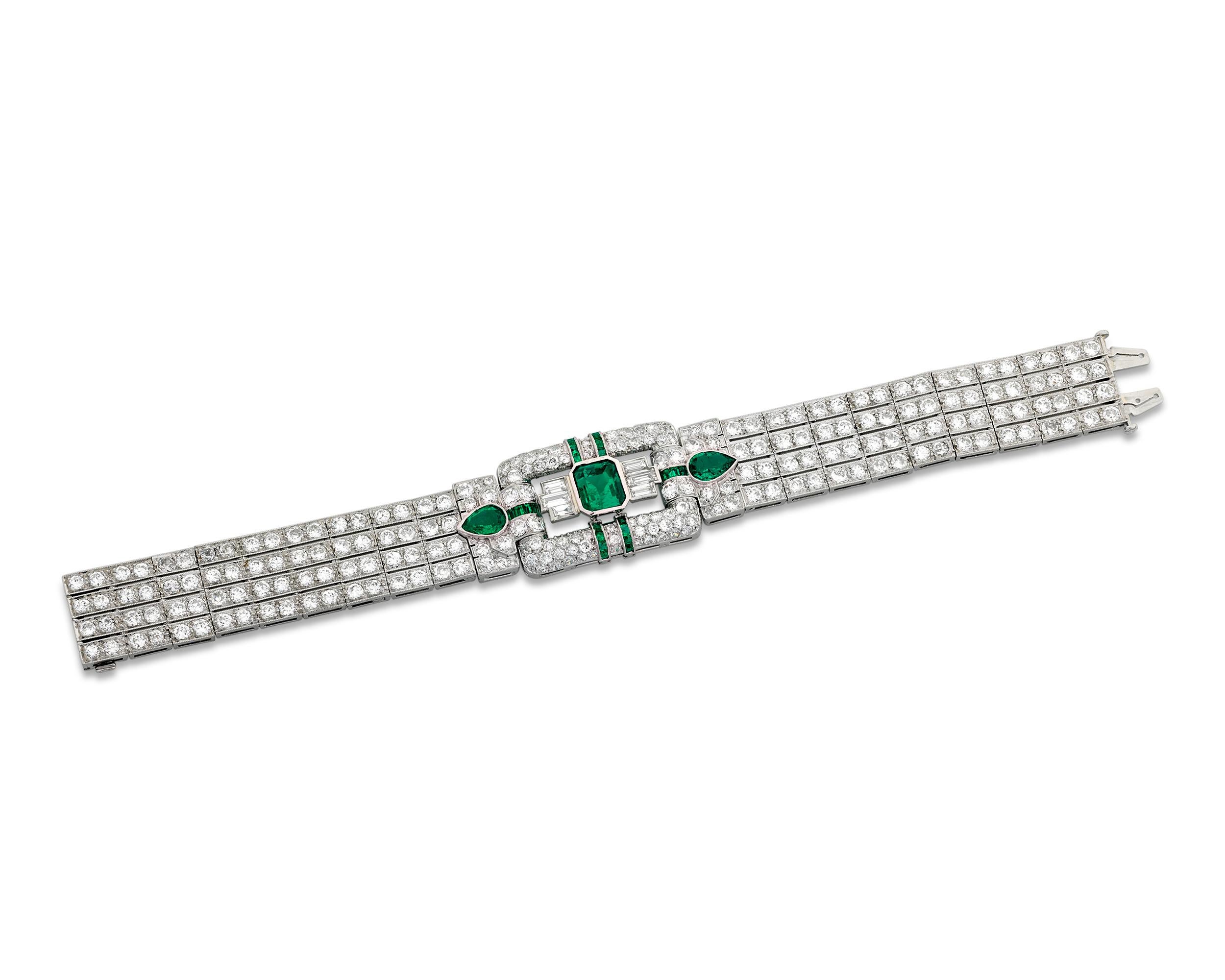 This outstanding Art Deco-period bracelet is the epitome of modern glamour. A remarkable 16.90 total carats of diamonds and emeralds encase the streamlined design, including an impressive 2.46-carat emerald at the center of the buckle-shaped