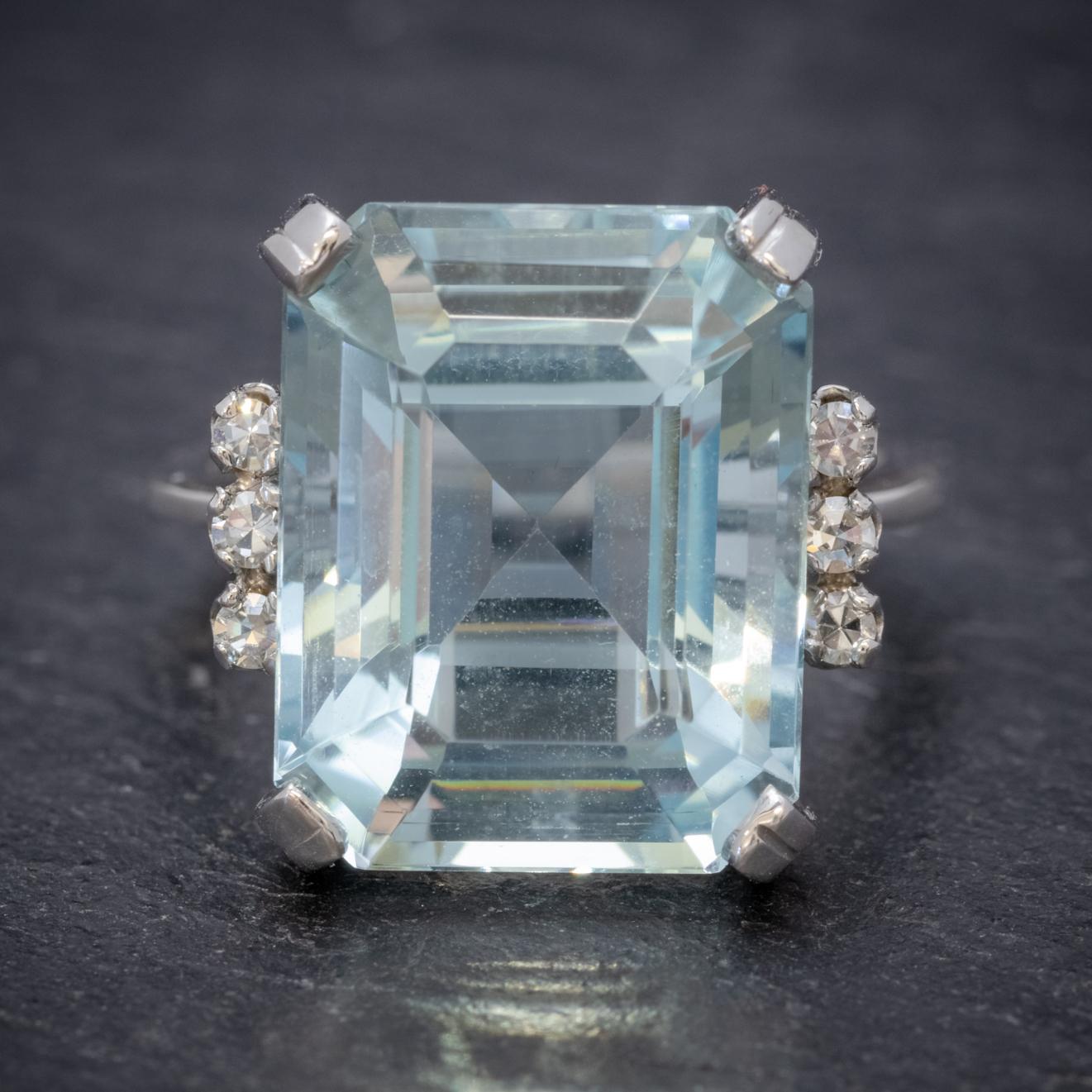 This magnificent Art Deco ring is claw set with a breath-taking emerald cut Aquamarine which is approx. 7ct flanked by three sparkling Diamonds on each shoulder which total to 0.12ct. 

The stones are showcased in an extravagant 18ct White Gold