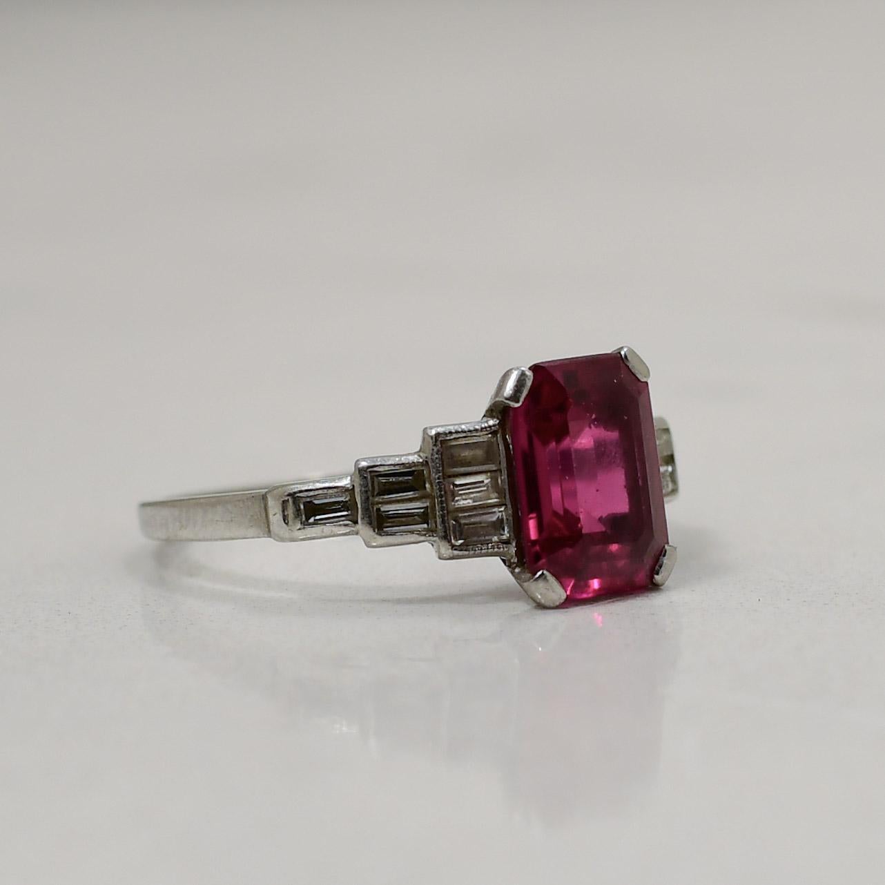 This exquisite vintage-inspired platinum ring showcases a lab-grown ruby of unparalleled quality, meticulously cornered within a rectangular faceted setting that evokes timeless elegance. The rich, crimson hue of the lab-grown ruby is accentuated by