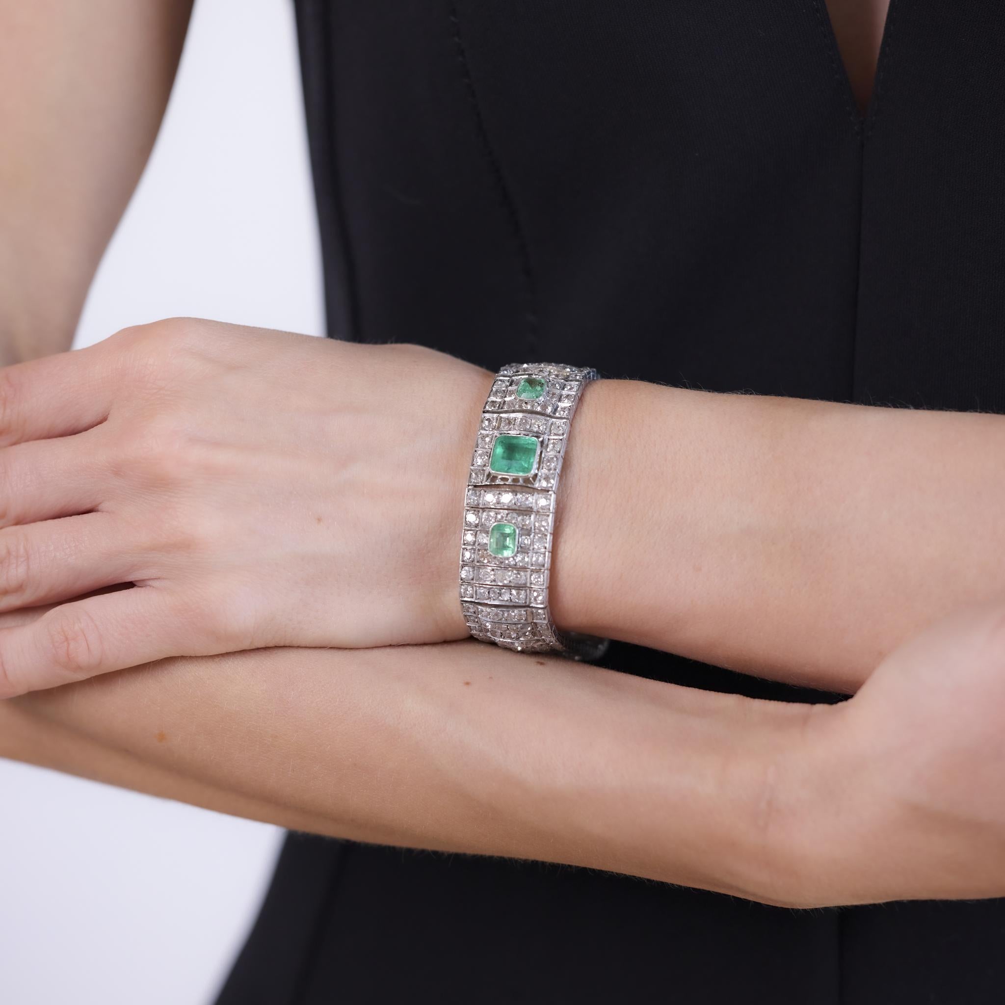 This magnificent Art Deco bracelet from the 1930s is crafted in 14k white gold and features a total of approximately 4.80 carats of emeralds, including a 3 carat center emerald cut stone and two emerald cut accents totaling 1.80 carats. Surrounding