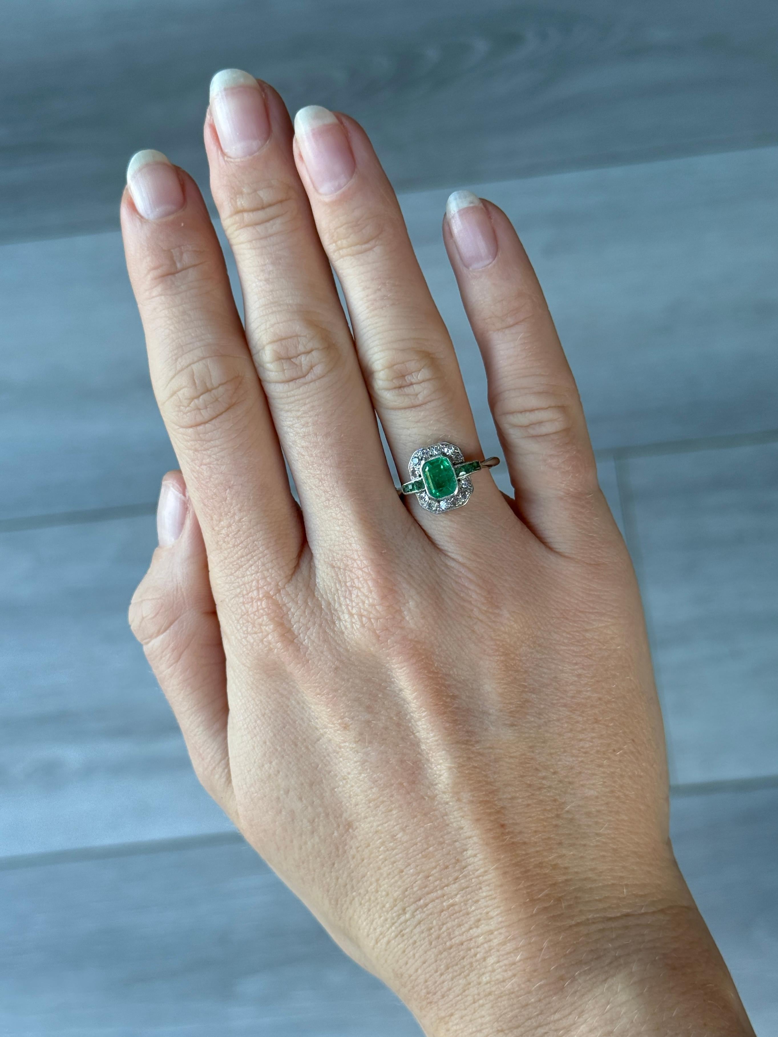 This ring is gorgeous and holds a gorgeous bright emerald and sparkling diamonds. The emerald measures approx 50pts and the diamond total is approx 36pts. Modelled in 18 carat gold and stones set in platinum. 

Ring Size: J 1/2 or 5 
Cluster