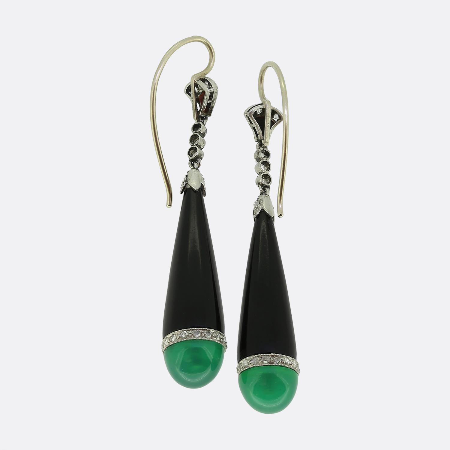Here we have an exquisite pair of drop earrings, crafted with precision and elegance at a time when the Art Deco style was at the forefront of world design. These earrings feature a striking combination of materials, with a sleek platinum setting.
