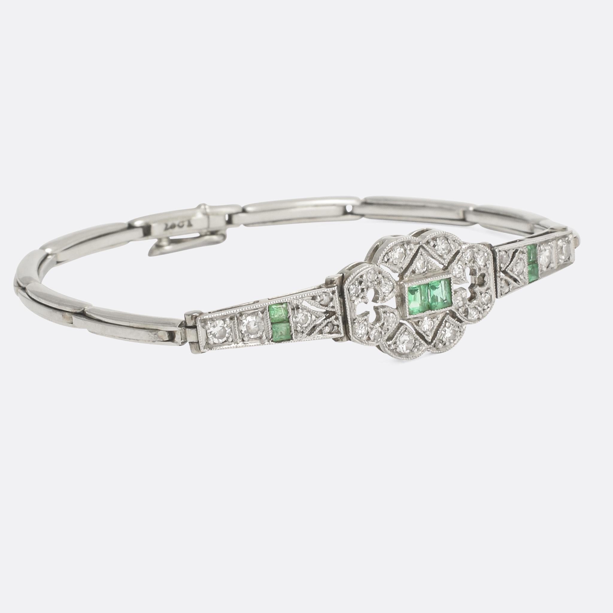An outstanding Art Deco bracelet set with emeralds and diamond. The head is intricately openworked, with clover / clubs and chevron motifs and finished in lovely millegrain throughout. Modelled in 18 karat white gold with platinum settings, it's