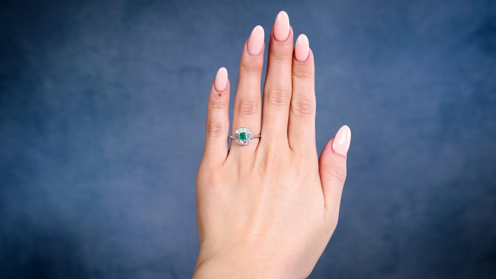 One Art Deco Emerald Diamond Platinum Ring. Featuring one carre cut emerald weighing approximately 0.20 carat. Accented by four carre, four old European, and four single cut diamonds with a total weight of approximately 0.50 carat, graded I-J color,