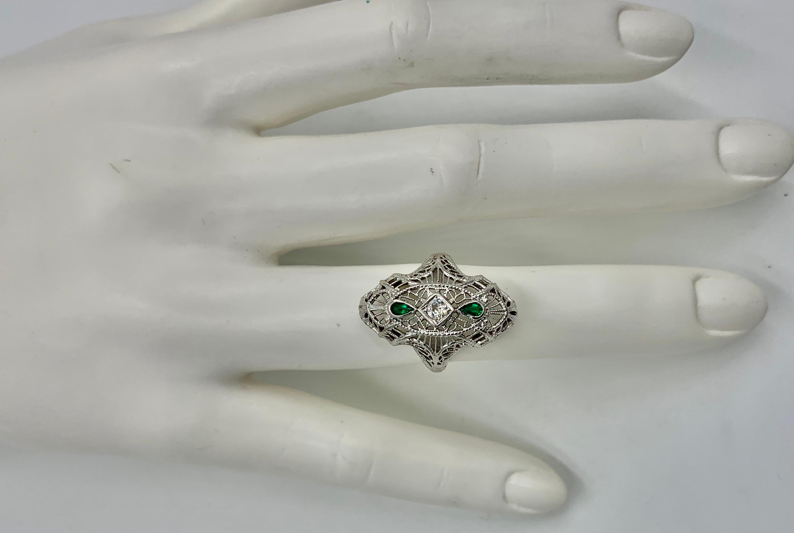 This is a stunning Antique Art Deco - Edwardian Emerald and Diamond Wedding Ring Engagement Ring set with a gorgeous Old Mine Cut Diamond in the center with two pear shape Emerald gems in an exuberant filigree engraved setting in 14 Karat White