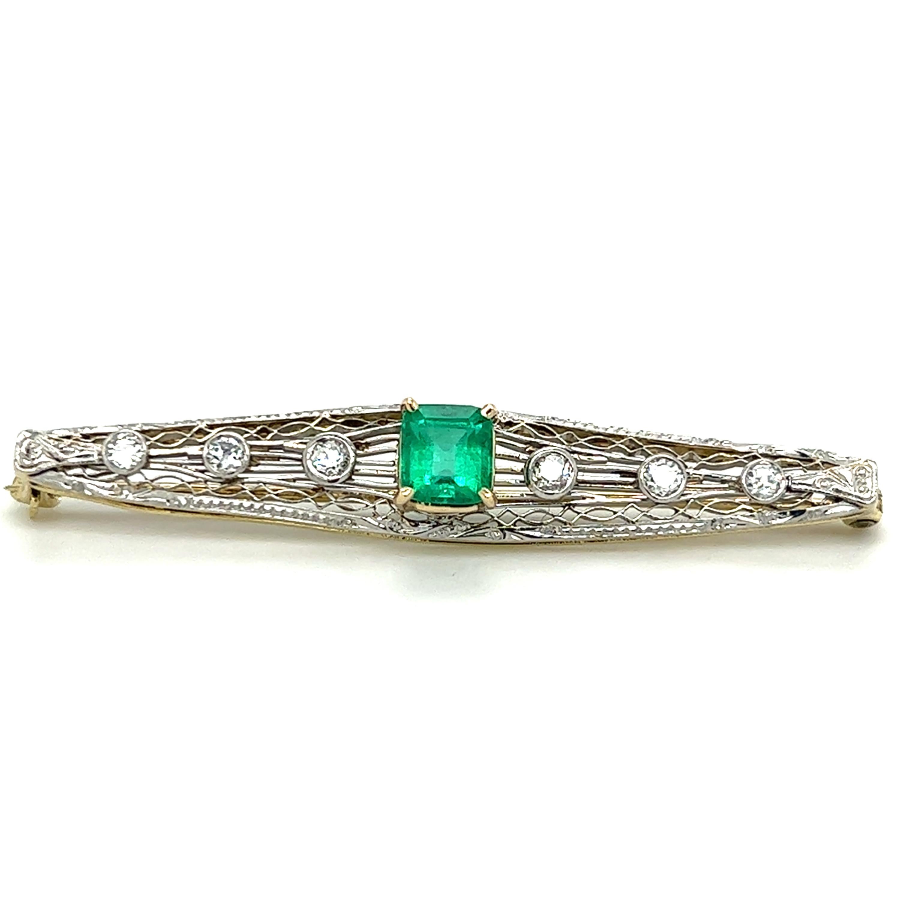 One 14 karat white and yellow gold filigree bar pin set with one (1) 0.88 carat natural emerald cut emerald and six (6) bezel set European cut diamonds, approximately 0.33 carat total weight with matching H/I color and SI/I1 clarity.  The pin