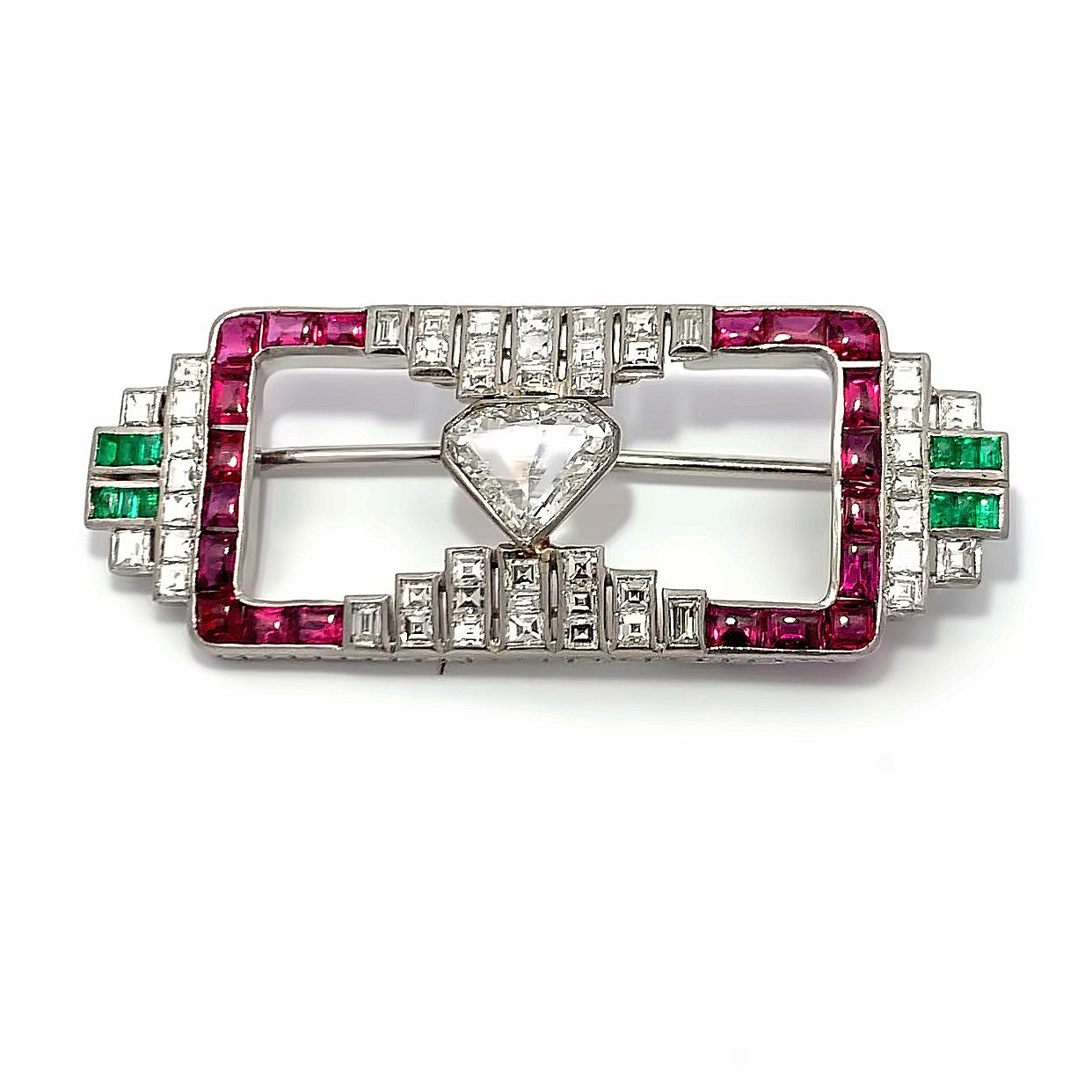 Art Deco Emerald Ruby and Diamond Brooch

An art deco platinum brooch set with diamonds, rubies, and emeralds. 

Approximate Stone Weights: 
Center Diamond: 1.18
Emeralds: .30
Buff top cabochon Rubies: 2.00
Baguettes: 2.60

Made circa