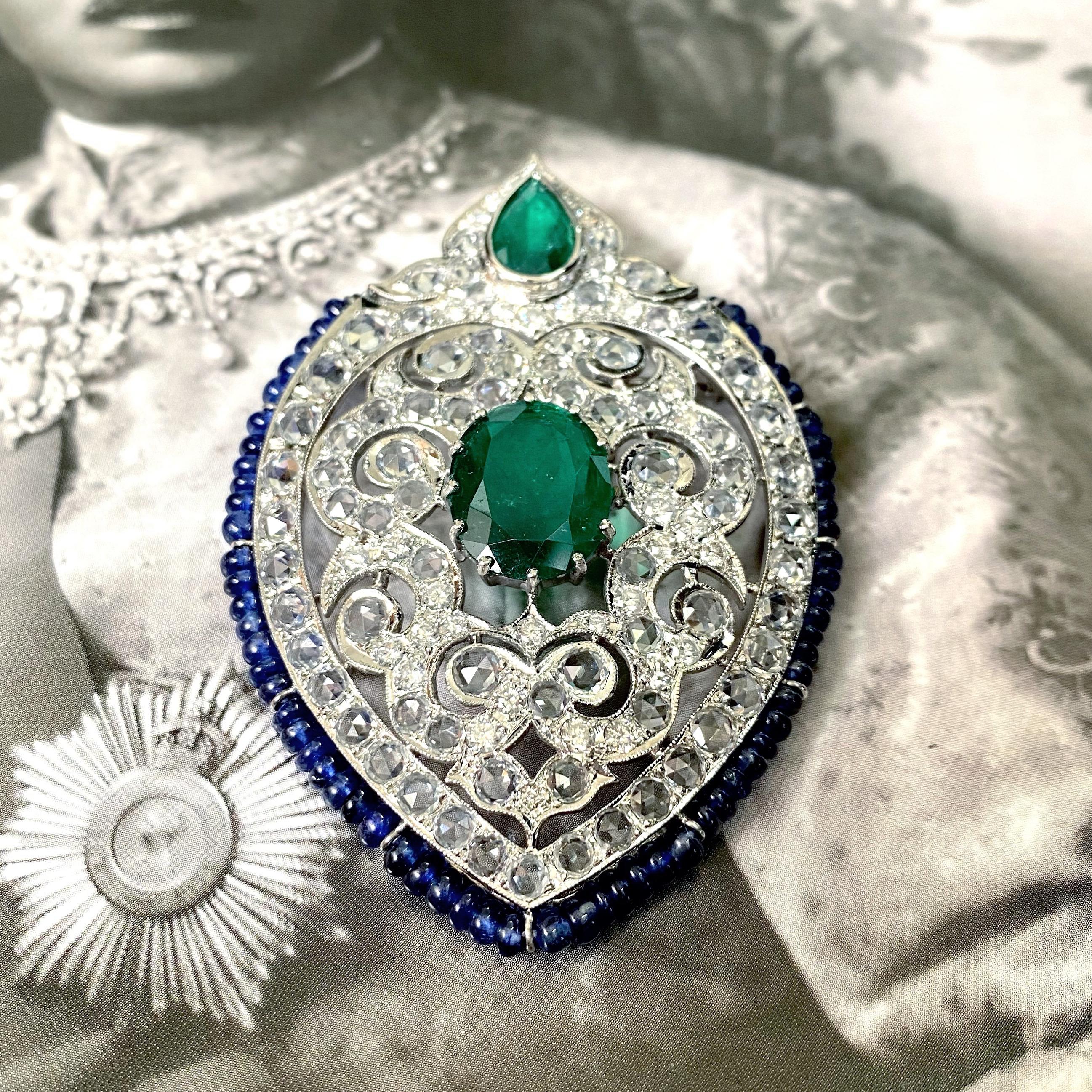 A stunning art-deco brooch, with Zambian Emeralds, Blue Sapphire beads, rose-cut White Sapphires and Diamonds - all set in solid 18K White Gold. The size of the brooch is around 7cm x 4.5cm. The Emeralds are natural, with great vivid green color and