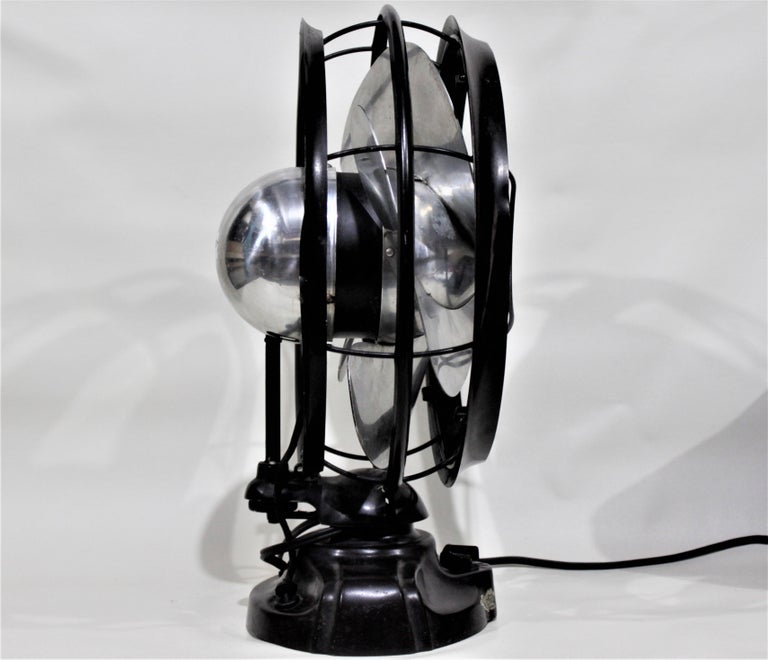 This industrial stream lined oscillating fan was made in the United States by Emerson Electric in the period and style of the Art Deco movement. The fan has a very heavy cast base with a three speed motor and a very machine aged constructed case
