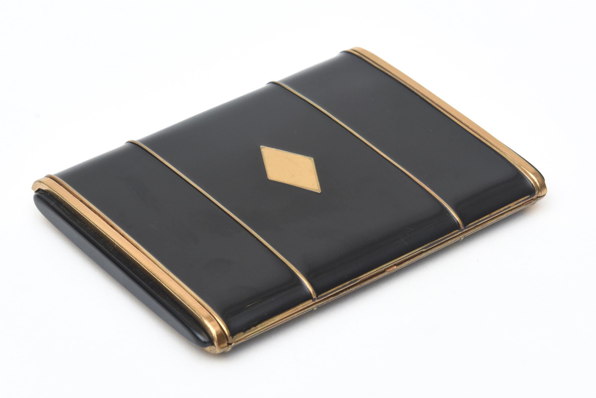 This stunning period art deco card case was once a cigarette case from the era. it is black enamel and gold metal with a diamond center form. It should be kept in a jewelers bag in one's handbag so there are not more scratches on it. It is