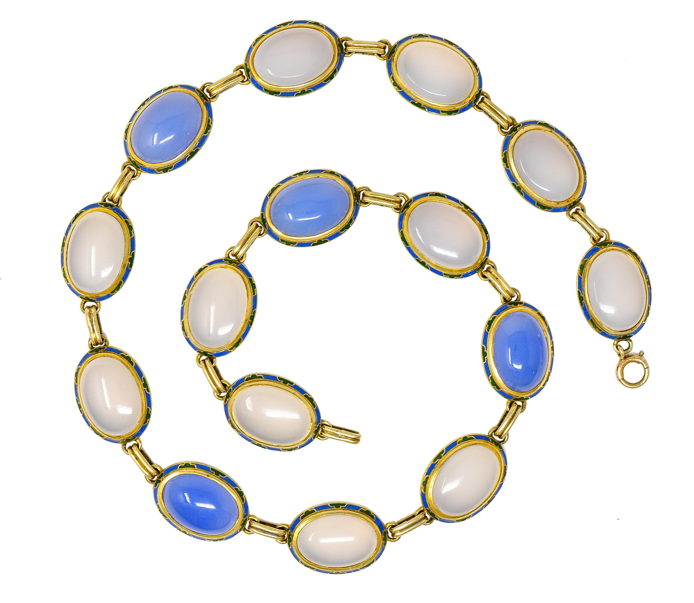 Necklace is comprised of links containing bezel set oval chalcedony cabochons

Translucent with natural pastel blue color and dyed violetish blue color

With polished gold surrounds glossed with cornflower blue and green enamel

Opaque and depicting