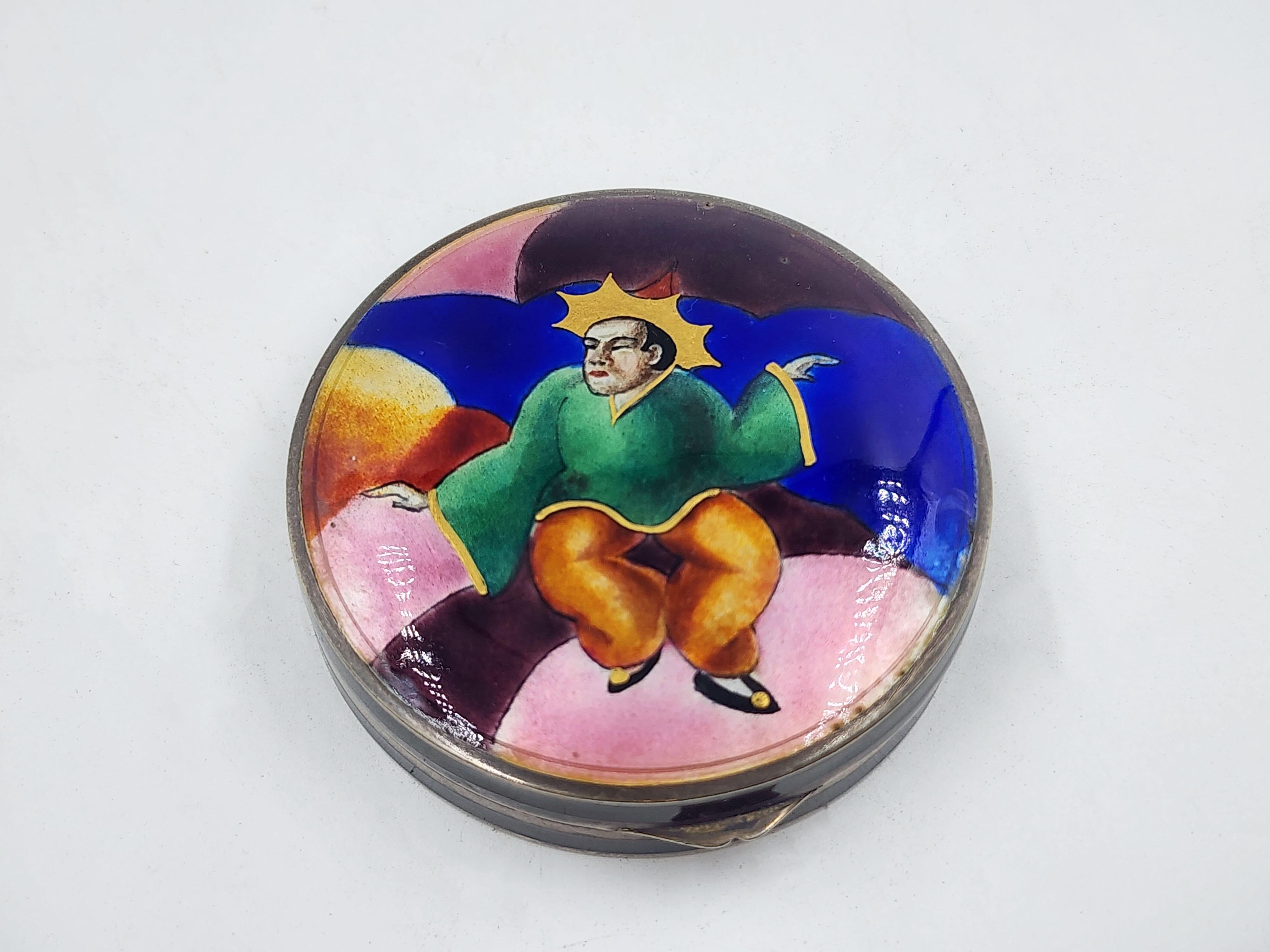 Caja de esmalte Art Déco de estilo Paul Laszlo y Maria Rott
Caja austriaca de esmalte Art Decó, pieza circular con tapa que representa una escena pintada a mano. La imagen central representa una figura humana, vestida con una túnica verde y