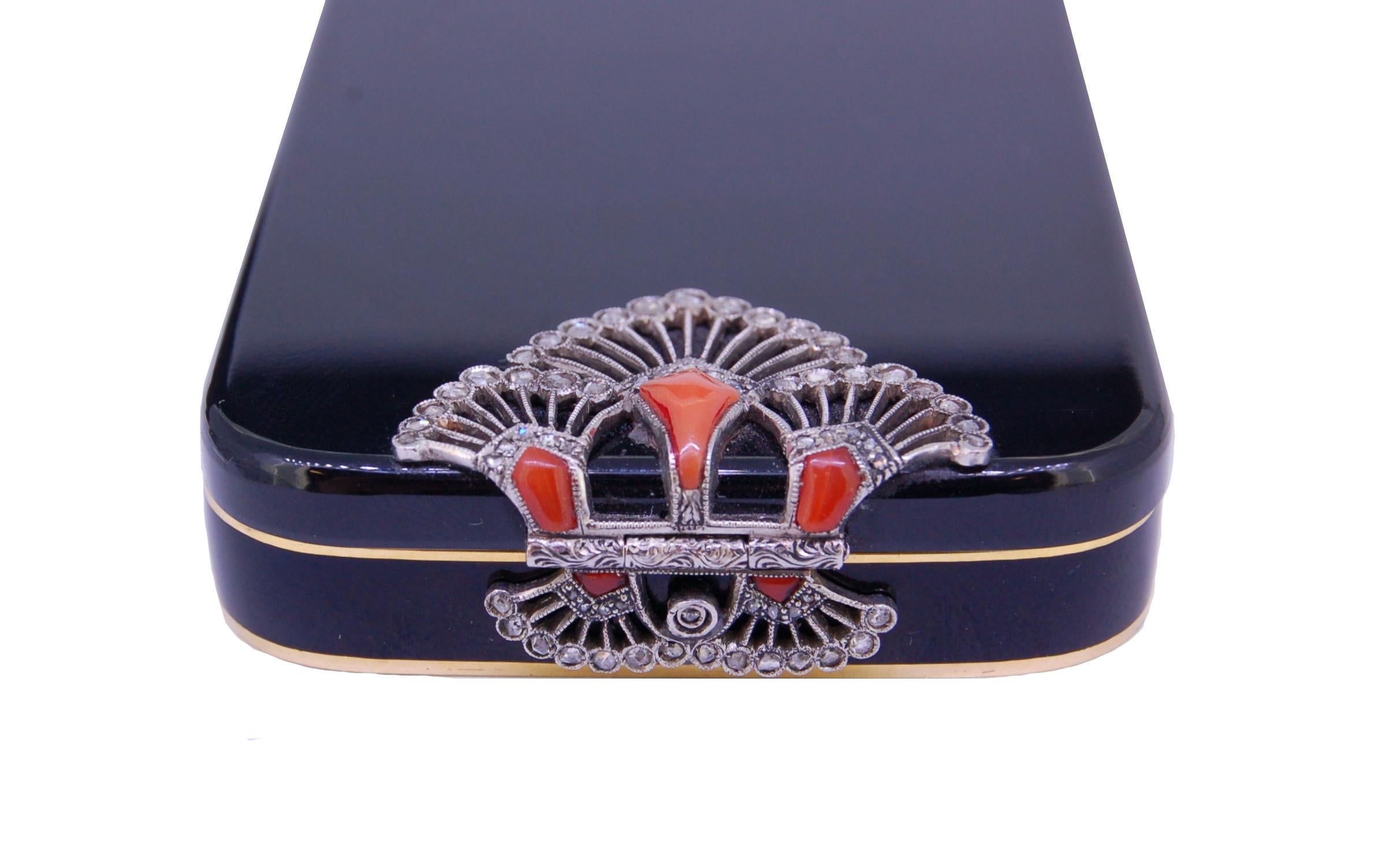 ART-DECO ENAMEL, DIAMOND AND CORAL POWER COMPACT,  18kt gold, the rectangular body with rounded corners decorated with black enamel to the cover and body. The cover and body set on the short sides with a fan shaped openwork applique set with