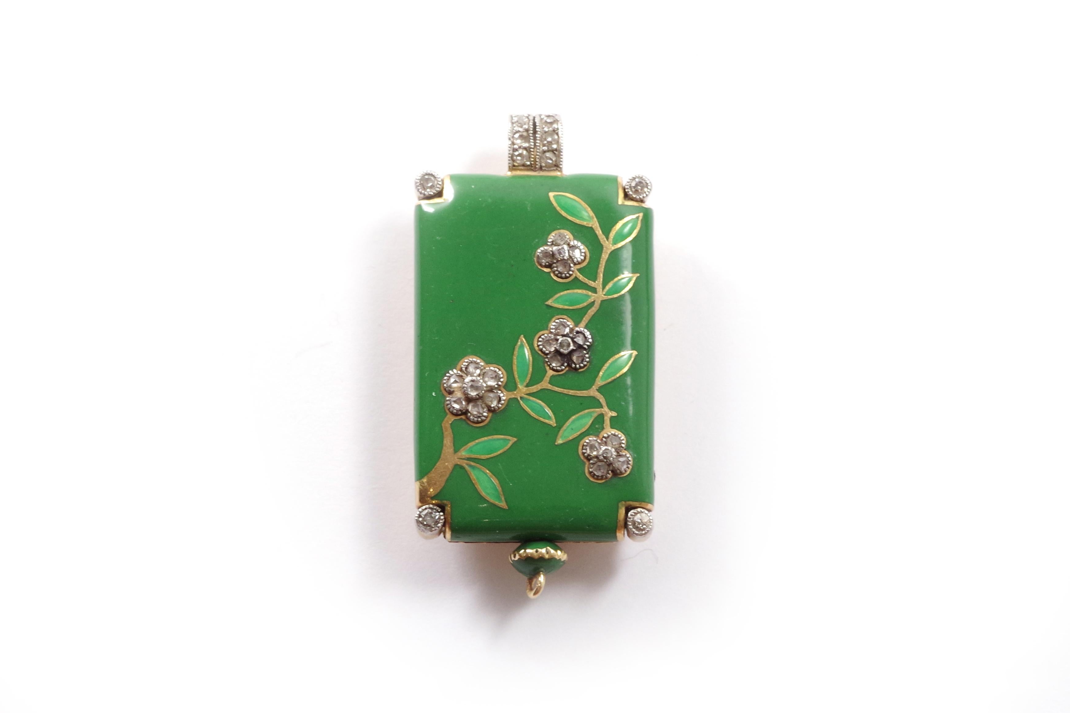 Art Deco enamel pendant watch in 18 karat yellow gold and platinum. A rare rectangular-shaped pendant watch, enameled on one side in green color and adorned with a blossoming branch motif influenced by Japanese Arts. The four flowers are represented