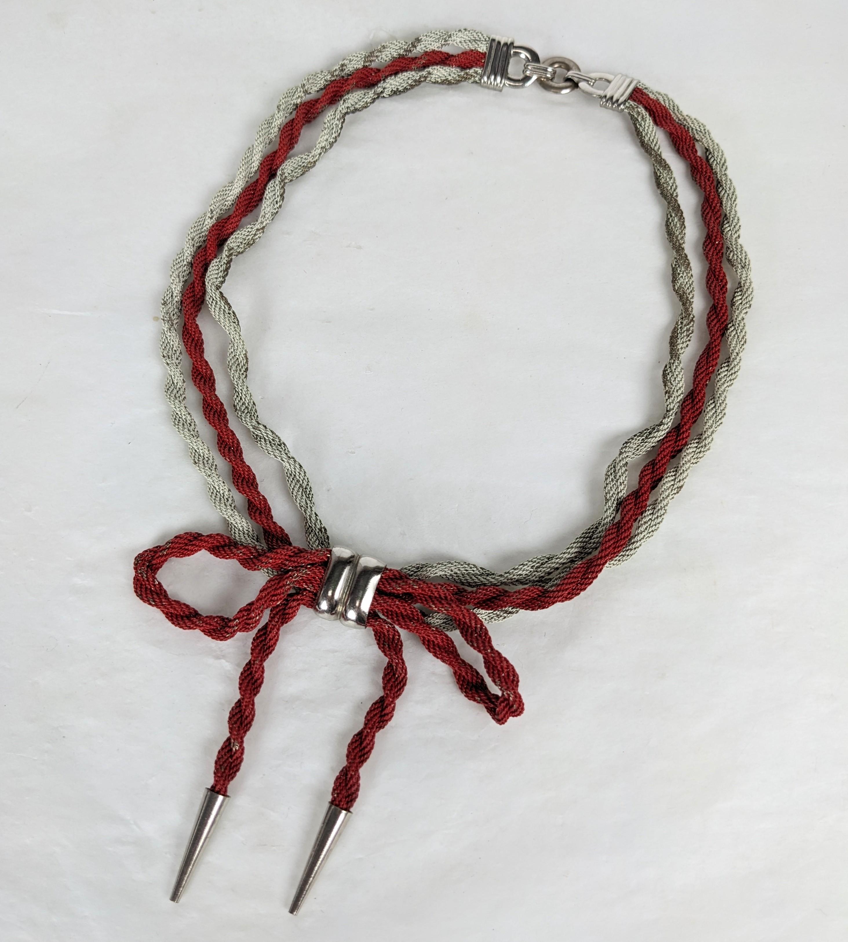 Affascinante collana a fiocco in maglia smaltata Art Deco degli anni '30. La catena intrecciata è smaltata in bianco e rosso per formare una collana con motivo a fiocco e finiture cromate. 15