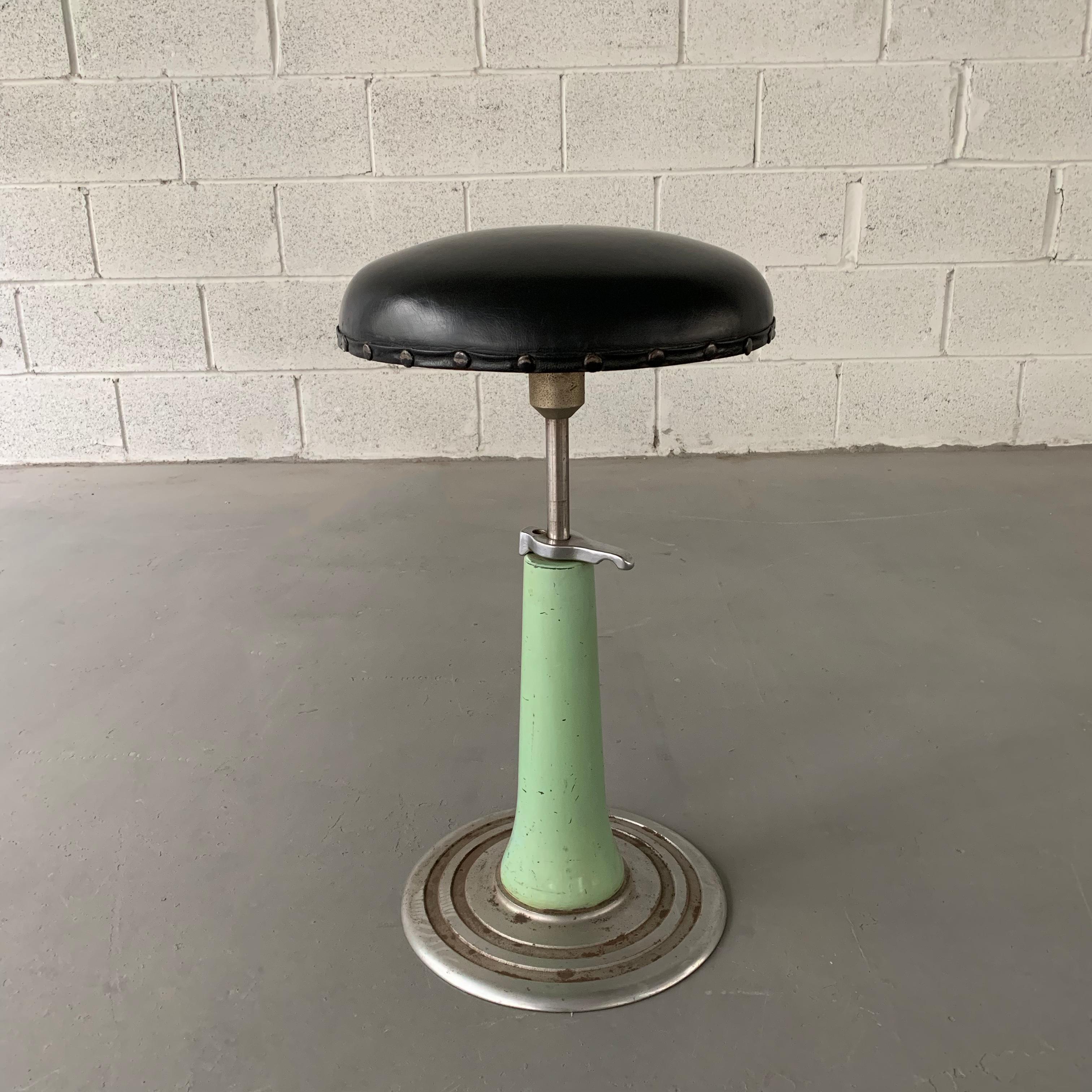 Art deco, apothecary, dentist stool by KEM Weber features a painted steel pedestal base that is adjustable from 20-30 inches height with 13 inch diameter, vinyl upholstered seat with nail head trim.