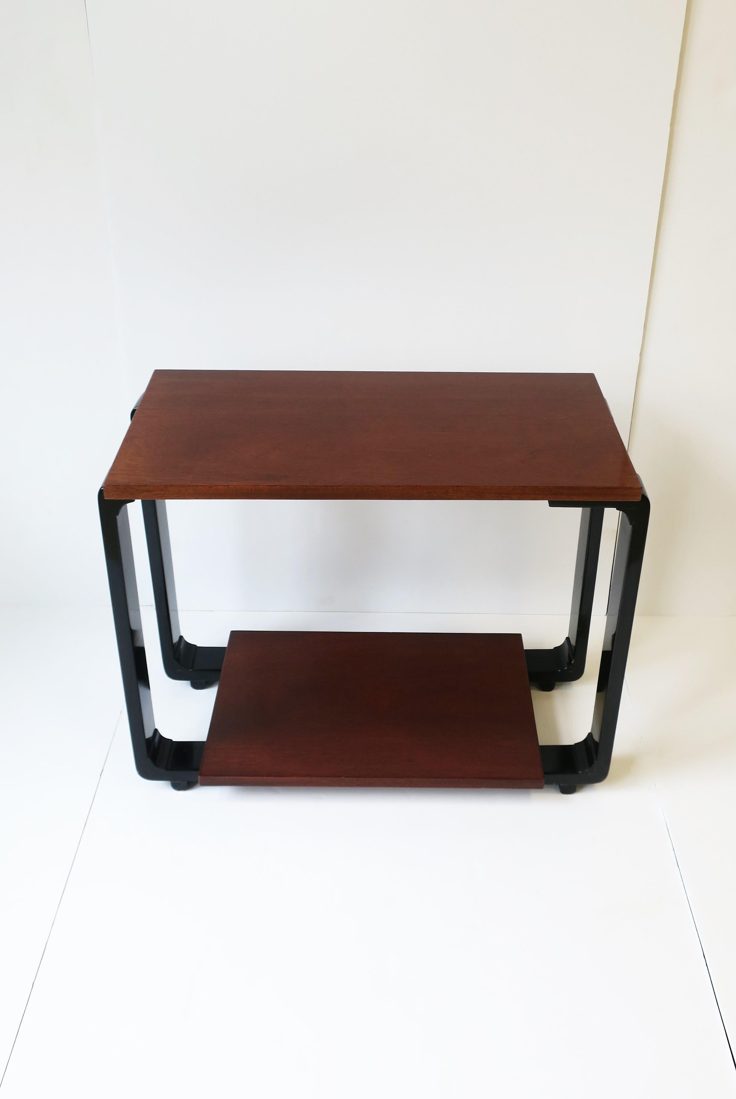 A rectangular end table, Art Deco Revival design, circa 1990s, Europe. Table has a brown top and base shelf area with black lacquered 'legs'. A relatively slim piece; make work well next to a sofa's arm as an end table, in-between two chairs, or