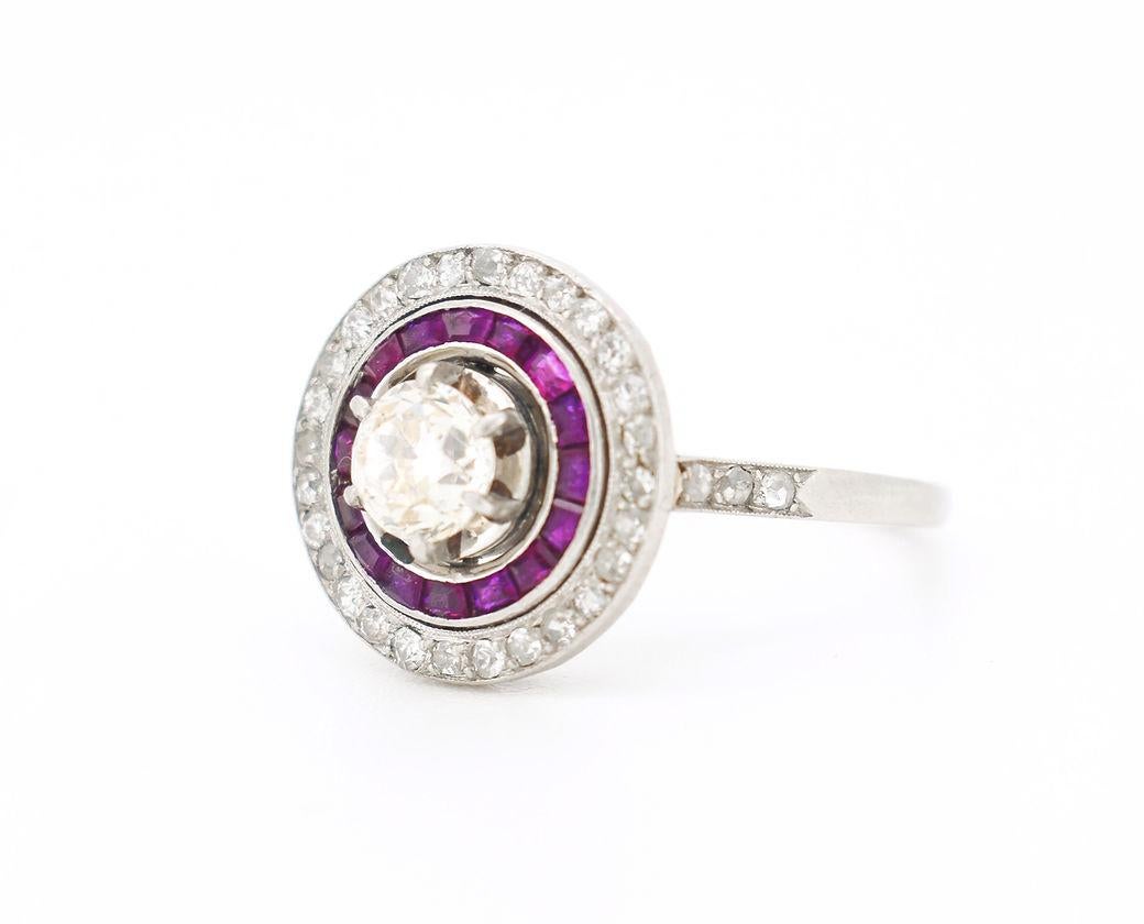 This Art Deco engagement ring, dating from circa 1930, is a remarkable example of the era’s refined craftsmanship. Made of platinum, it features a central old-cut diamond weighing approximately 0.50 carat, set within a striking double halo—one of