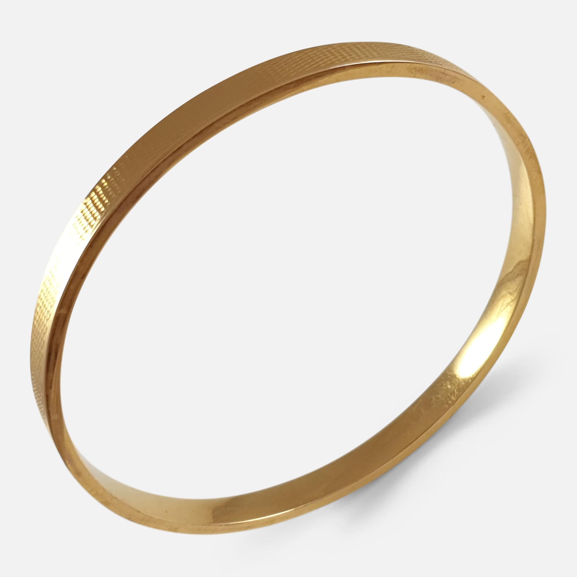 An Art Deco engine turned 15 karat yellow gold hollow Flapper bangle. The bangle is UK hallmarked, stamped '15.625' to denote 15 karat (carat) gold, and London 1927.

Engraving: - None.

Measurement: - The internal diameter is 7.65cm. The internal