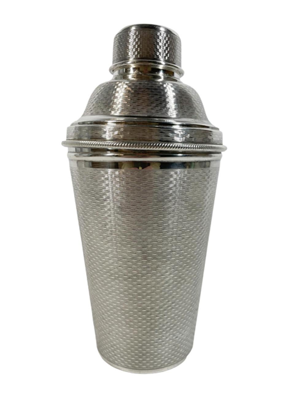 English Art Deco silver plate cobbler type cocktail shaker with allover engine turned decoration, the lid with an integral strainer and removable citrus reamer. Marked on the bottom 
