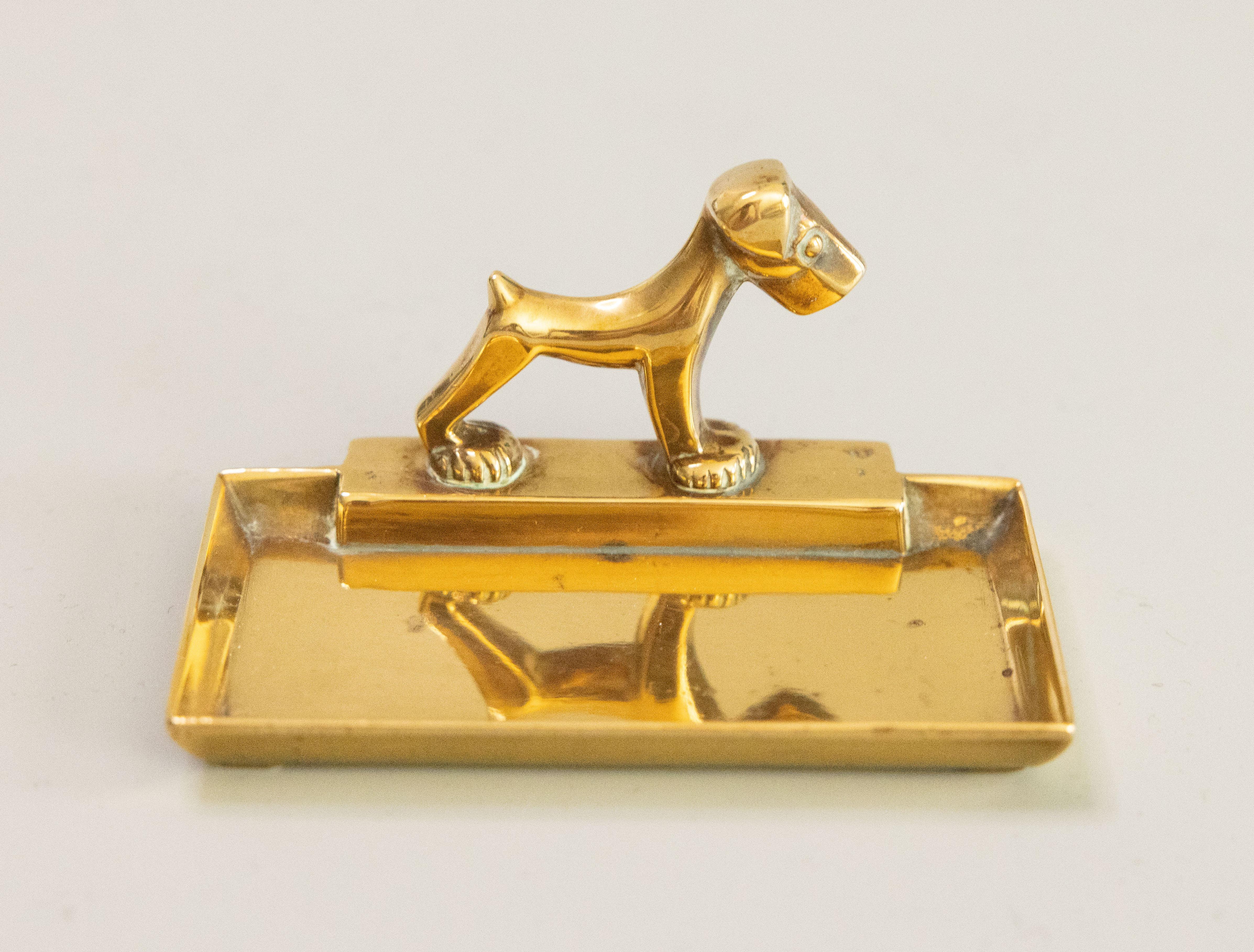A stylish antique early 20th Century Art Deco English cast brass terrier dog catchall tray or vide poche. Lovely brass patina. Perfect for jewelry, loose change, or keys.

Dimensions
3.6ʺW × 2.25ʺD × 1.75ʺH