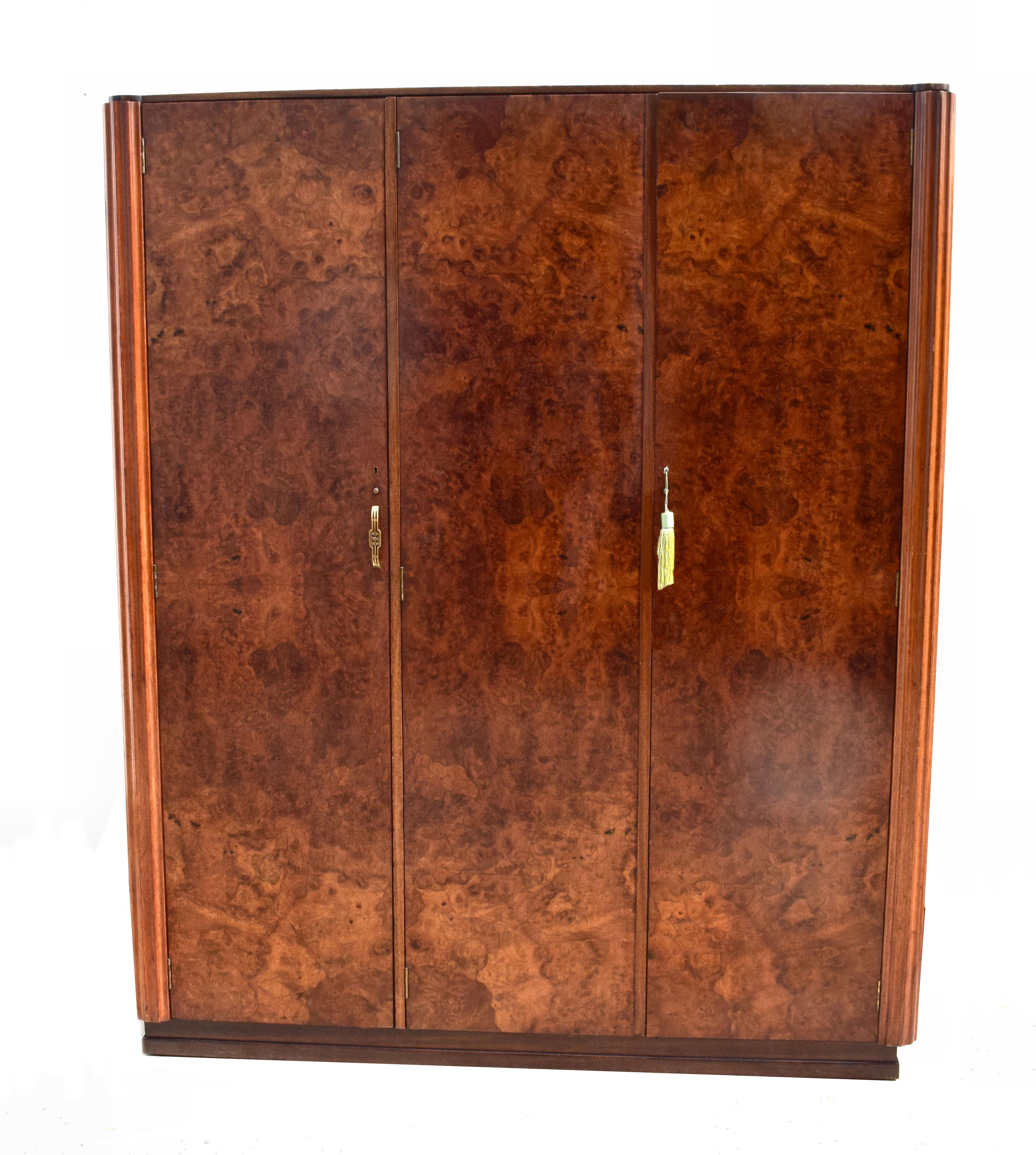 Superb and totally original is this 1930s Art Deco triple door wardrobe with working key. Not only does this wardrobe look impressive with its heavily figured veneers which match and follow on each door but it's extremely generous in the storage it