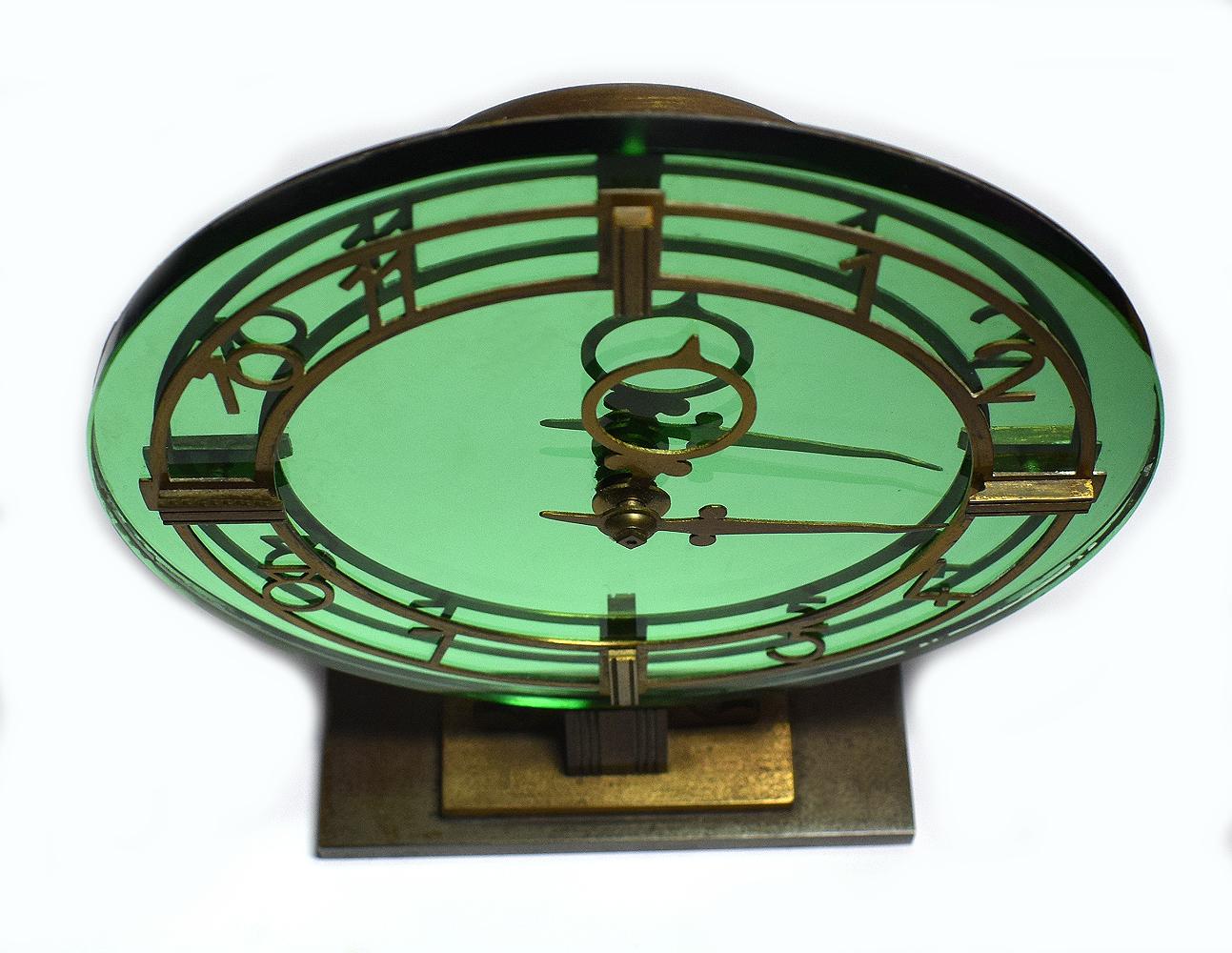 Very attractive SEC Smiths Art Deco modernist English clock. Made in England. Green mirrored background, very glamorous and finished off beautifully with a brass numerals. The dial sits on a solid brass stepped plinth. Good working order having been