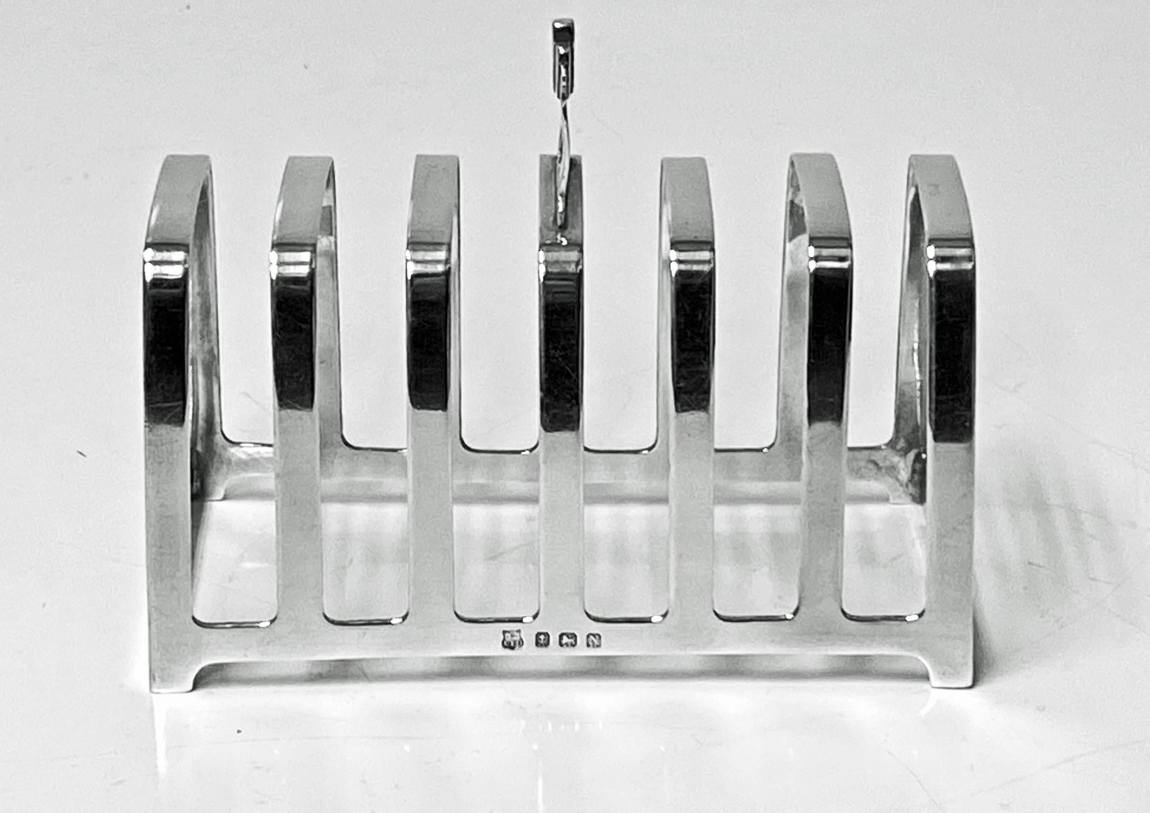 Art Deco English Sterling silver Toast or letter rack, Birmingham 1937 William Neale & Son. The six slice toast rack on rectangular base with stepped arched dividers and odeon arch style handle. Measures: Length: 4.75 inches depth:2.50 inches