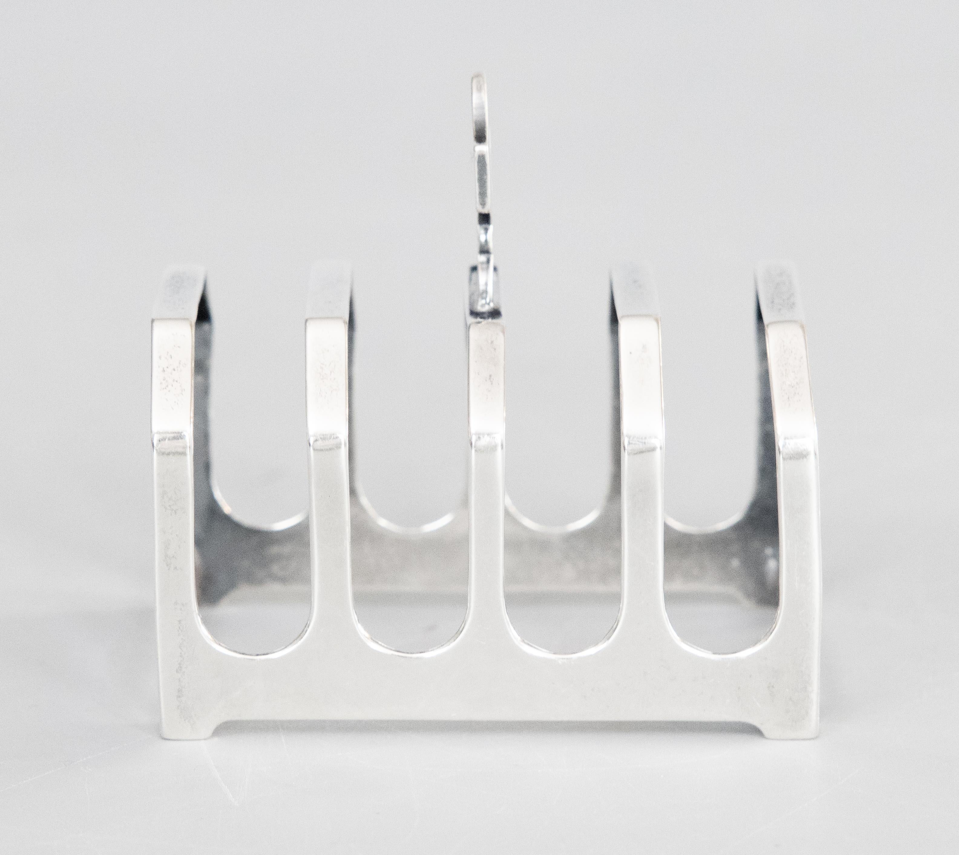 A lovely petite English sterling silver four slice toast rack by William Bruford & Son Ltd, London, dated 1936. Hallmarks on reverse. This fine quality silver toast rack is well made with with a lovely Art Deco style geometric shape and decorative