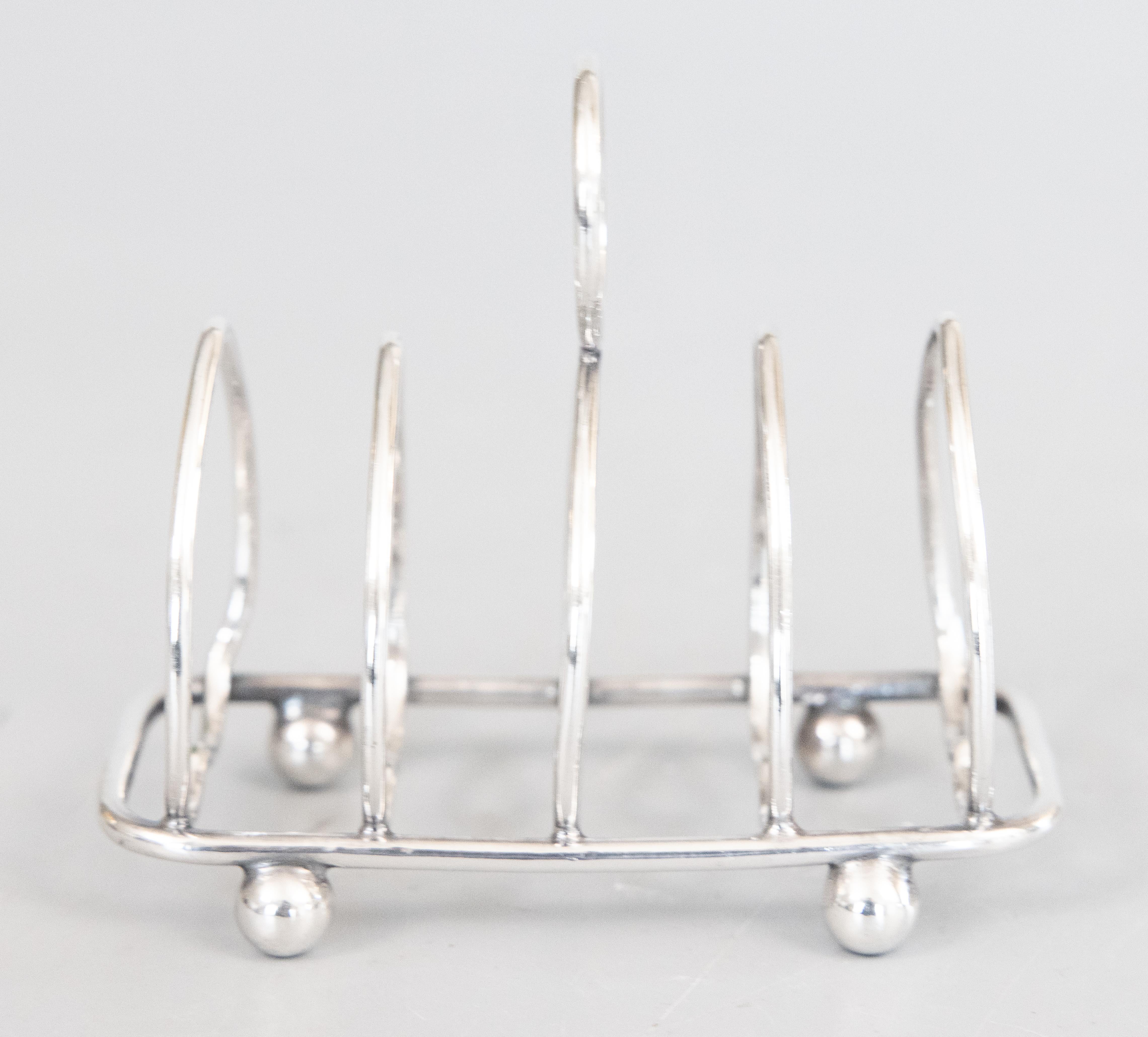 A lovely petite antique English sterling silver four slice toast rack. Hallmarks on reverse (the marks are worn from polishing but appear to be in the shape of the lion passant silver standard mark). This fine toast rack has a stylish Art Deco