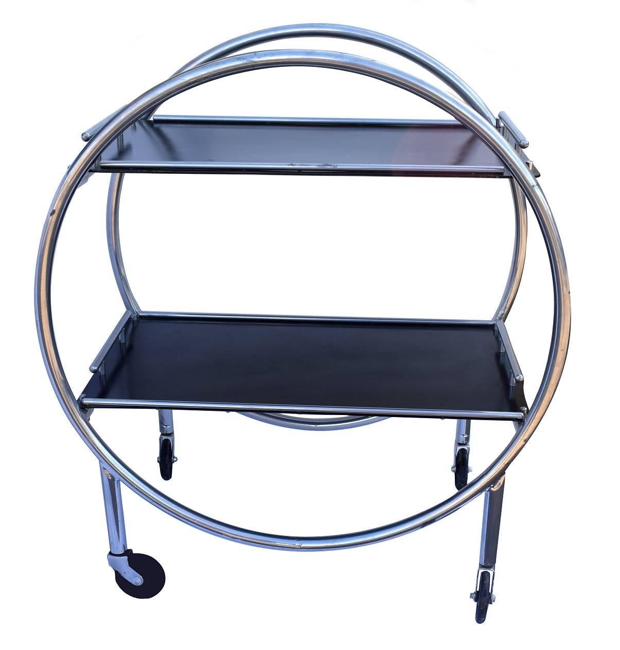 Stylish English 1930s Art Deco two-tier chrome and black laminate drinks hostess trolley bar cart. If glam is your thing then this is for you! In situ these carts look nothing less than amazing. Can be used for serving drinks or just displaying your