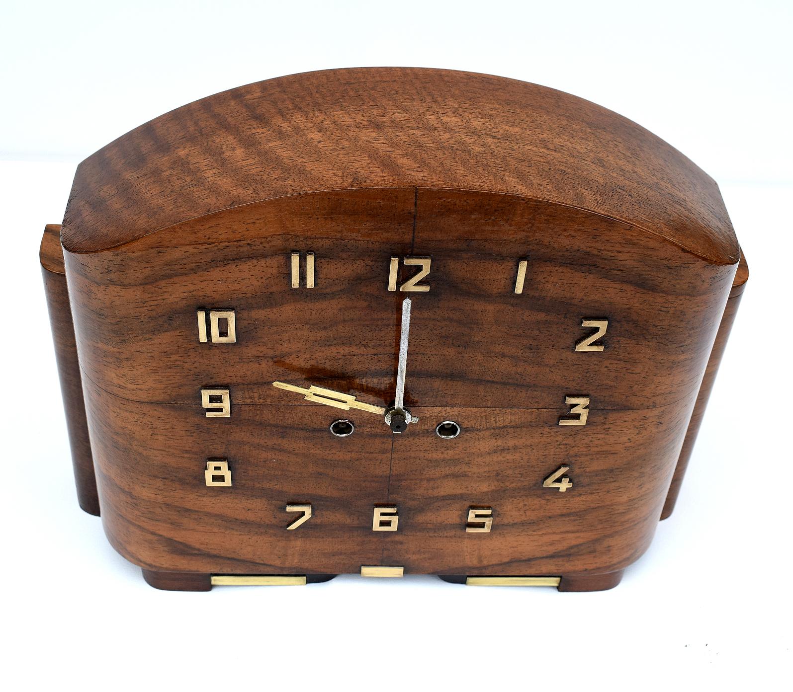 For your consideration is this English free standing 1930s Art Deco mantle clock. The case is made from Walnut and is embellished with brass Art Deco stylized numerals which are in relief. The movement is eight day and strikes on the hour. We've had