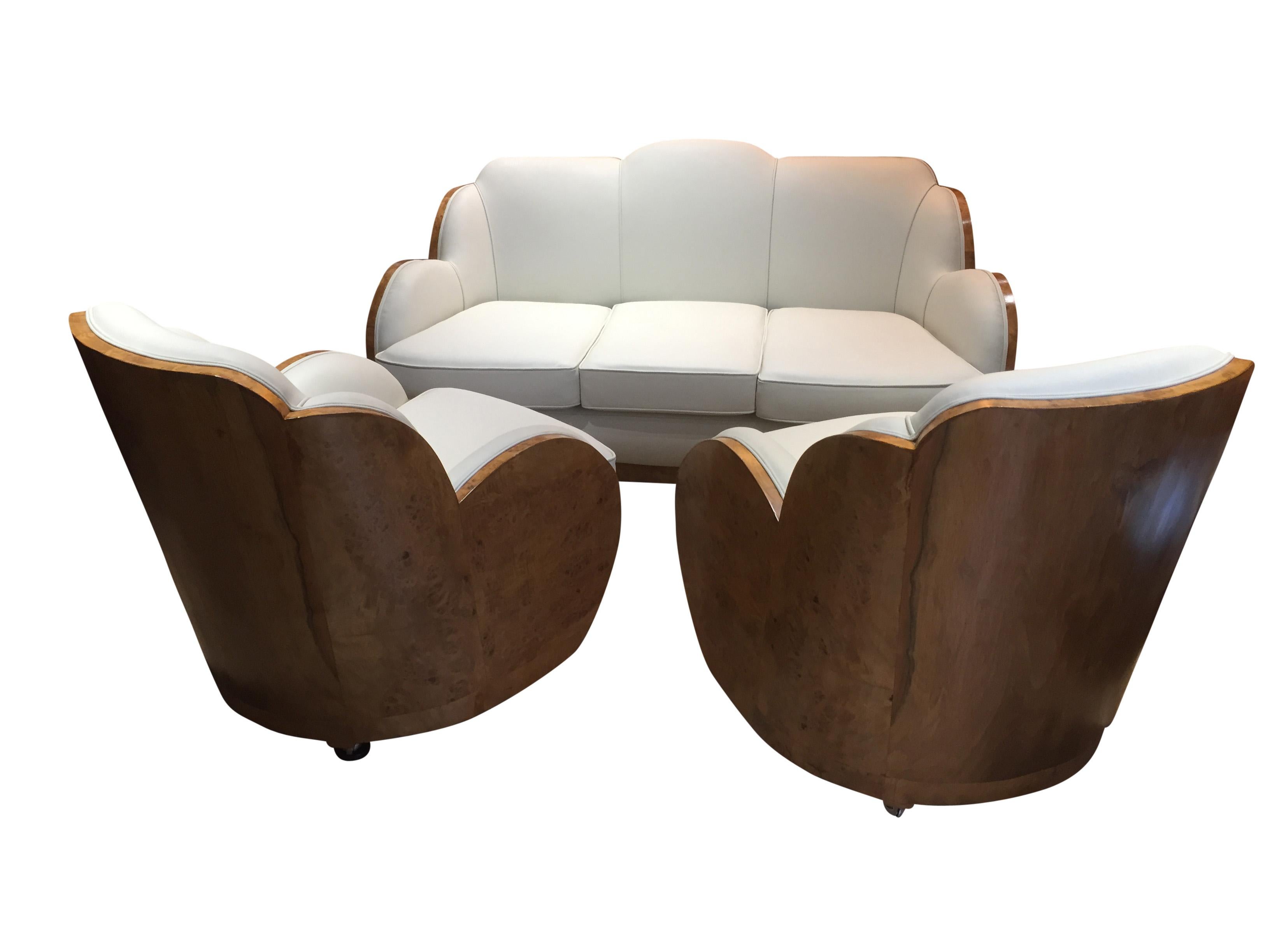 A top of the range Art Deco 3-piece cloud suite by Harry and Lou Epstein. The suite has just been reupholstered in soft cream leather. Each piece has a matching and a particularly striking walnut veneered back, whilst the sides of the armchairs and