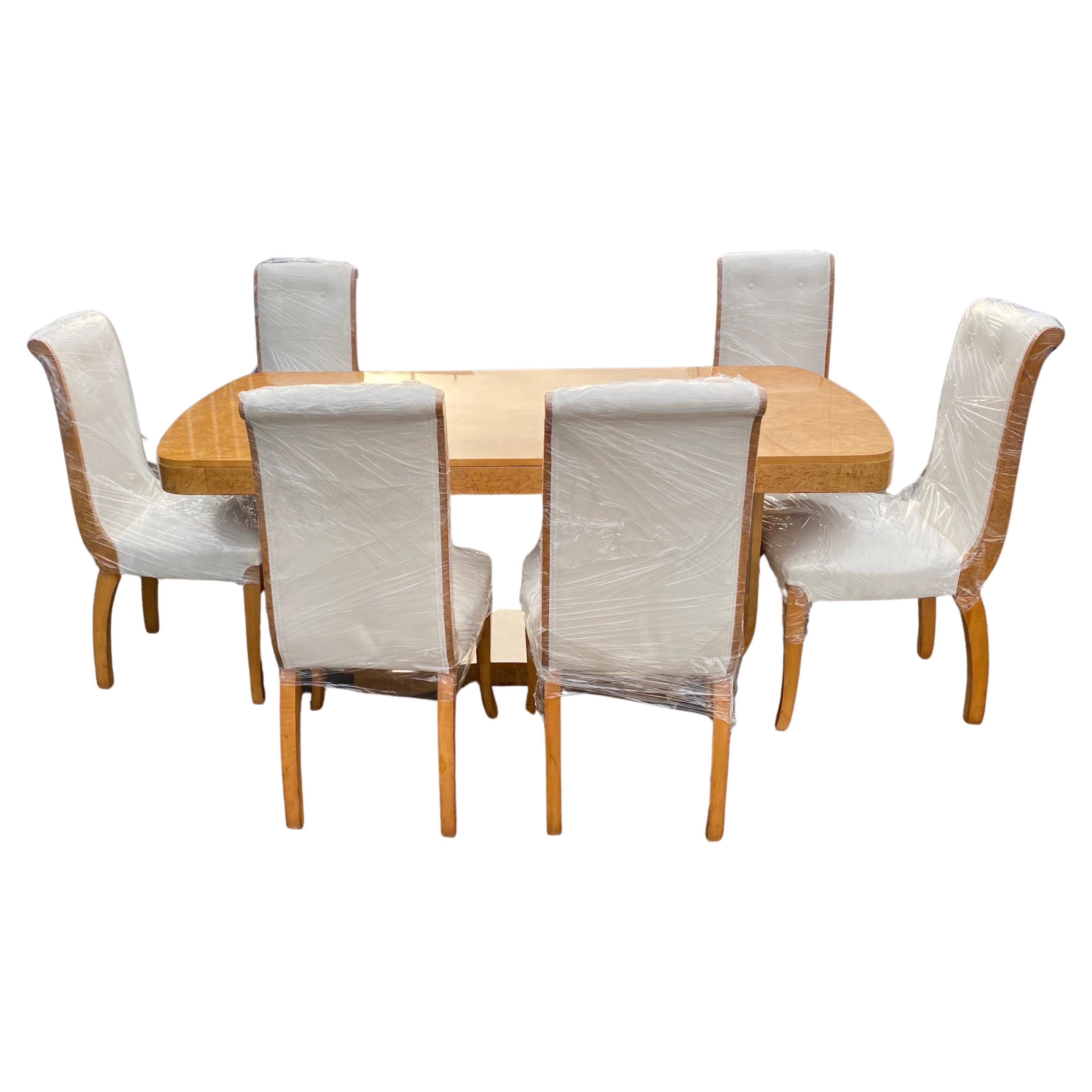 An original art deco Harry & Lou Epstein blonde wood dining Suite. 
A high quality Burr Maple Veneer set comprises of a stunning u shape base table with canted corner shaped top with protective glass and 6 beautiful Scroll Back Chairs. The matching