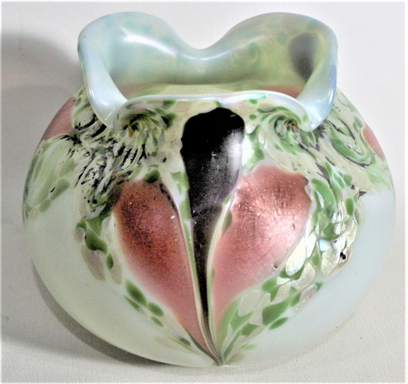 Questo vaso artigianale in vetro artistico non è firmato, ma si presume sia stato realizzato in Austria intorno al 1920 in stile Art Deco. Questo vaso ha un corpo bulboso e una sommità arricciata ed è realizzato con uno sfondo crema con decorazioni