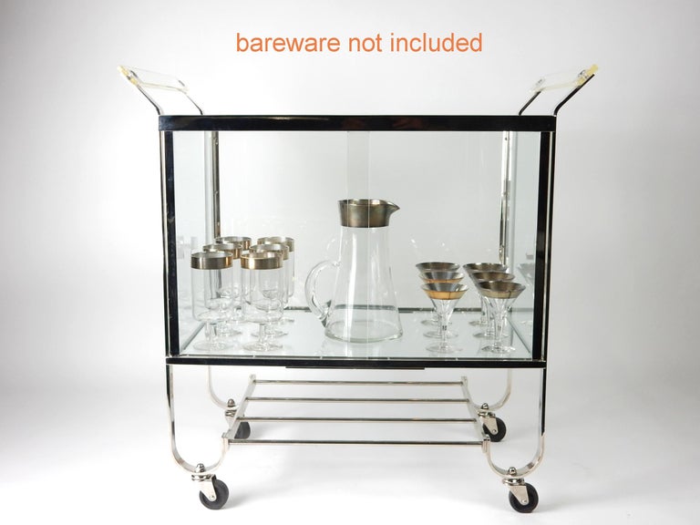 Fabulous chrome bar cart with enclosed glass cabinet center.
Proudly showcase your finest decanters and stemware!
Lucite handles. 2 sliding glass panel doors in front.
Designed by Treitel Gratz, circa 1940s.
This piece is in very good original