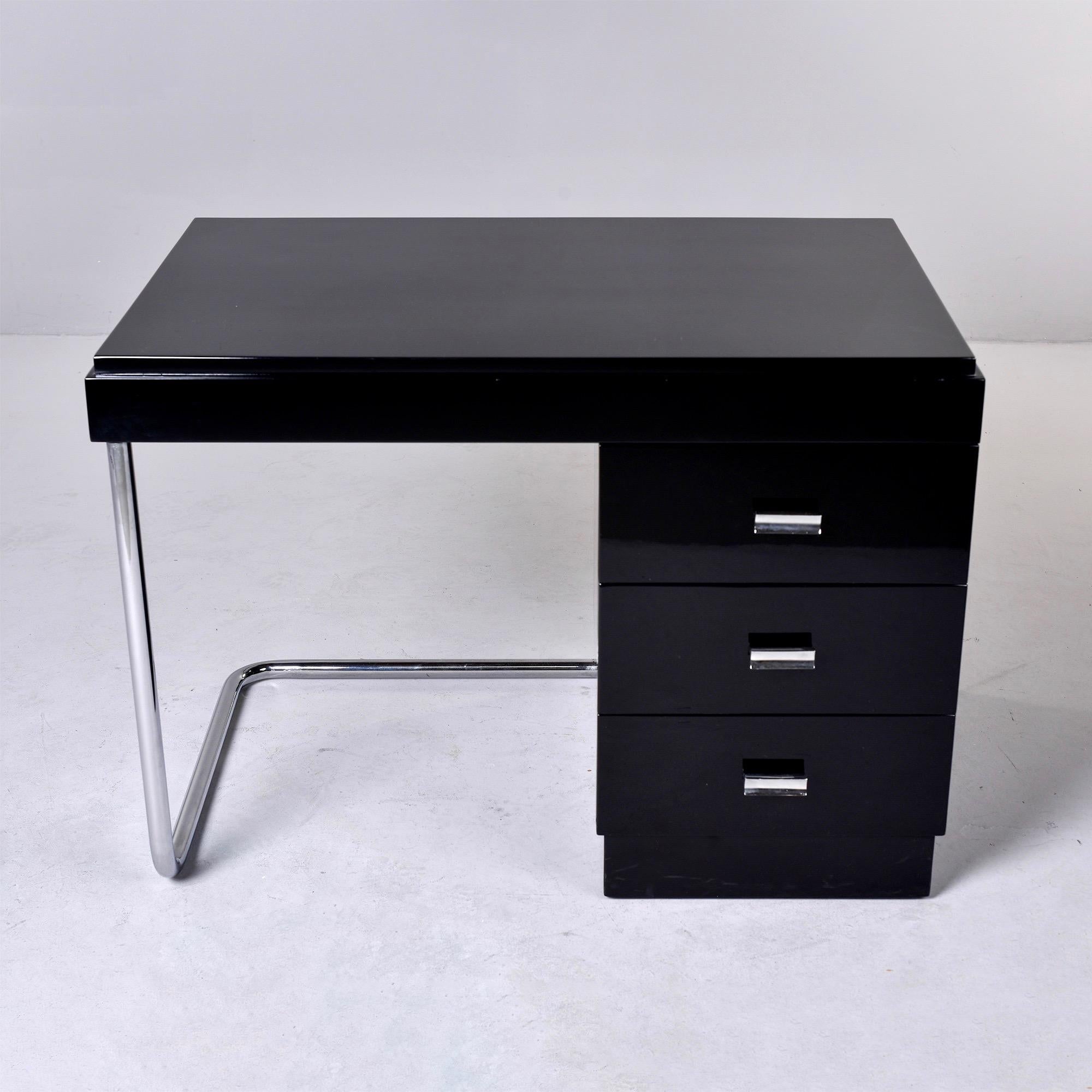 Found in England, this circa 1930s Art Deco desk has a streamlined machine age / industrial style. Desk top with three functional drawers and stainless steel leg and base. Unknown maker. Mahogany with new, professionally applied black finish.