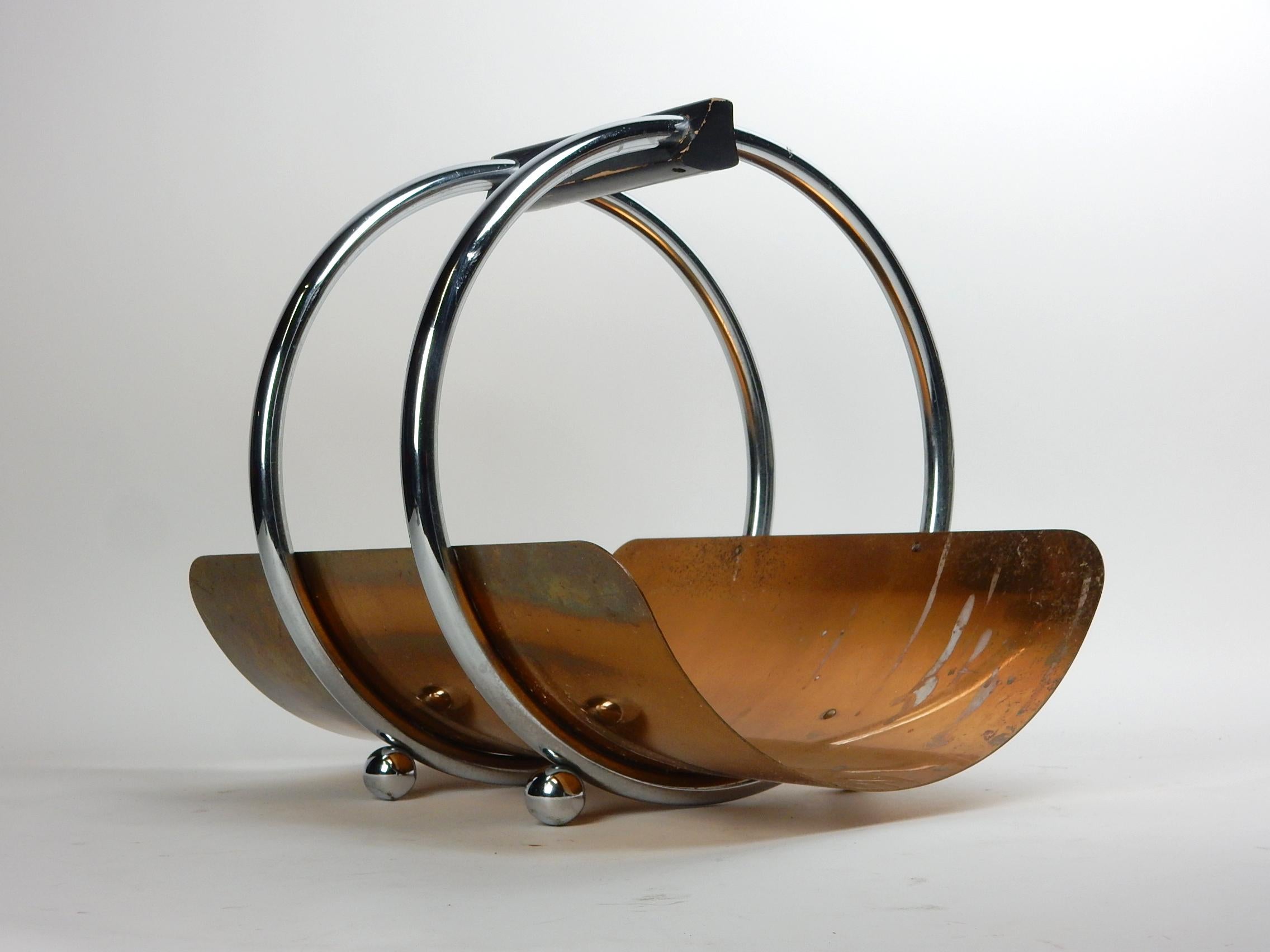 Art Deco chrome steel, copper and wood log or magazine stand
designed by Leslie Beaton for Revere, circa 1935.
Large wooden handle connects 2 large hoops with ball feet. Floating curved copper tray.
Solid, complete original condition.
