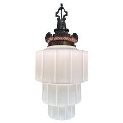 Lampada a sospensione in ottone ornato di epoca Art Deco con paralume a gradini in vetro latteo a forma di grattacielo