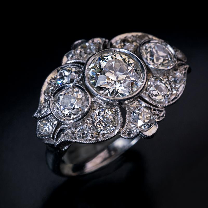 Circa 1930

This vintage Art Deco ring is crafted in platinum and densely set with old European cut and old mine cut diamonds.

The center stone is an old European cut diamond measuring 7.55 – 7.36 x 4.35 mm, approximately 1.53 ct (K color, VS1