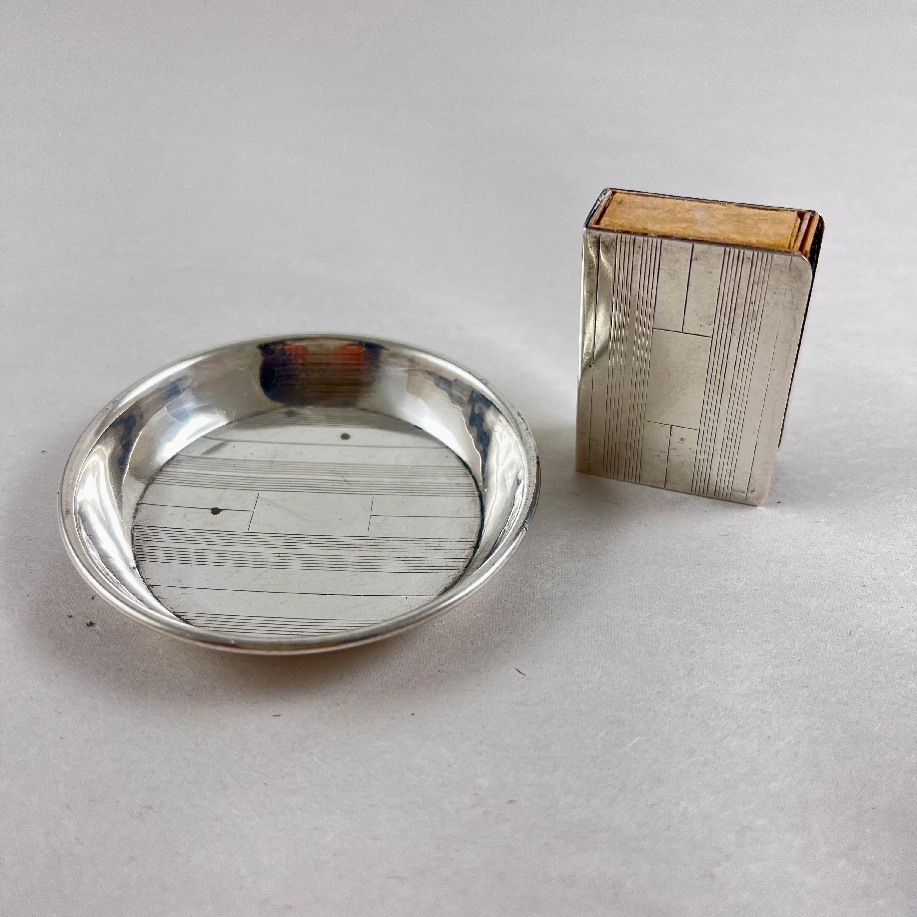 An Art Deco Era Sterling Silver smoke set, an ashtray and match book holder, made for personal use while traveling, circa 1920-1930.

This set fits neatly into a jacket pocket.

For the discerning gentleman, the two piece set shows an incised line