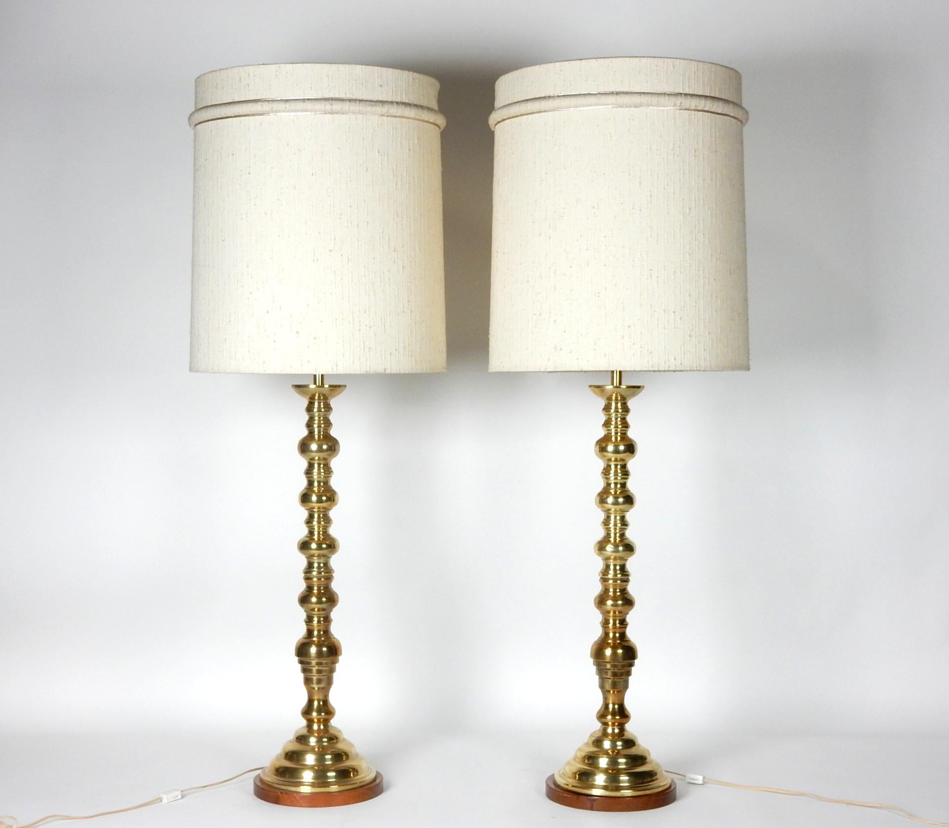 Monumental pair of solid brass candlestick table lamps.
Walnut base and double standard bulb sockets.
Not marked or signed by maker.
44