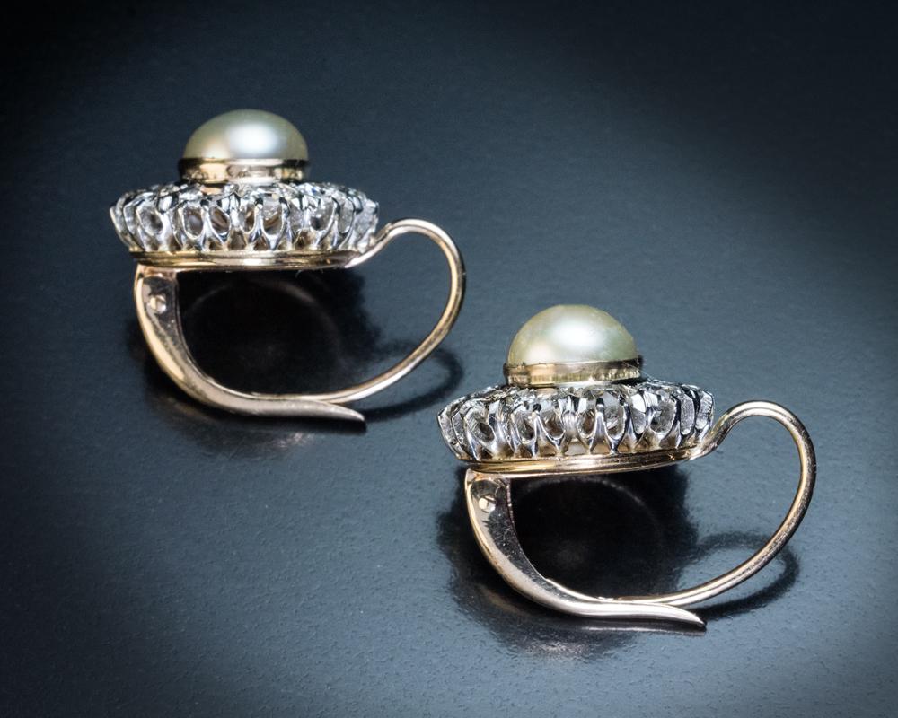 These Art Deco era, circa 1920s, platinum and 18K gold cluster earrings are centered with 7 mm pearls surrounded by bright white old European and transitional cut diamonds (F-G color, VS-SI clarity).

Estimated total diamond weight is 2.40